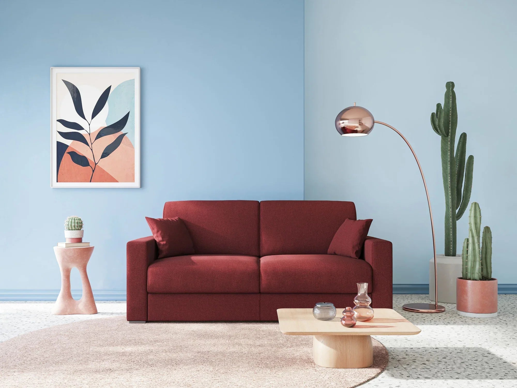 Un soggiorno moderno con un divano rosso, una lampada rotonda rosa, un tavolino da caffè in legno chiaro, cactus in vaso, una piccola pianta su un tavolino e un'arte astratta di foglie su una parete blu.