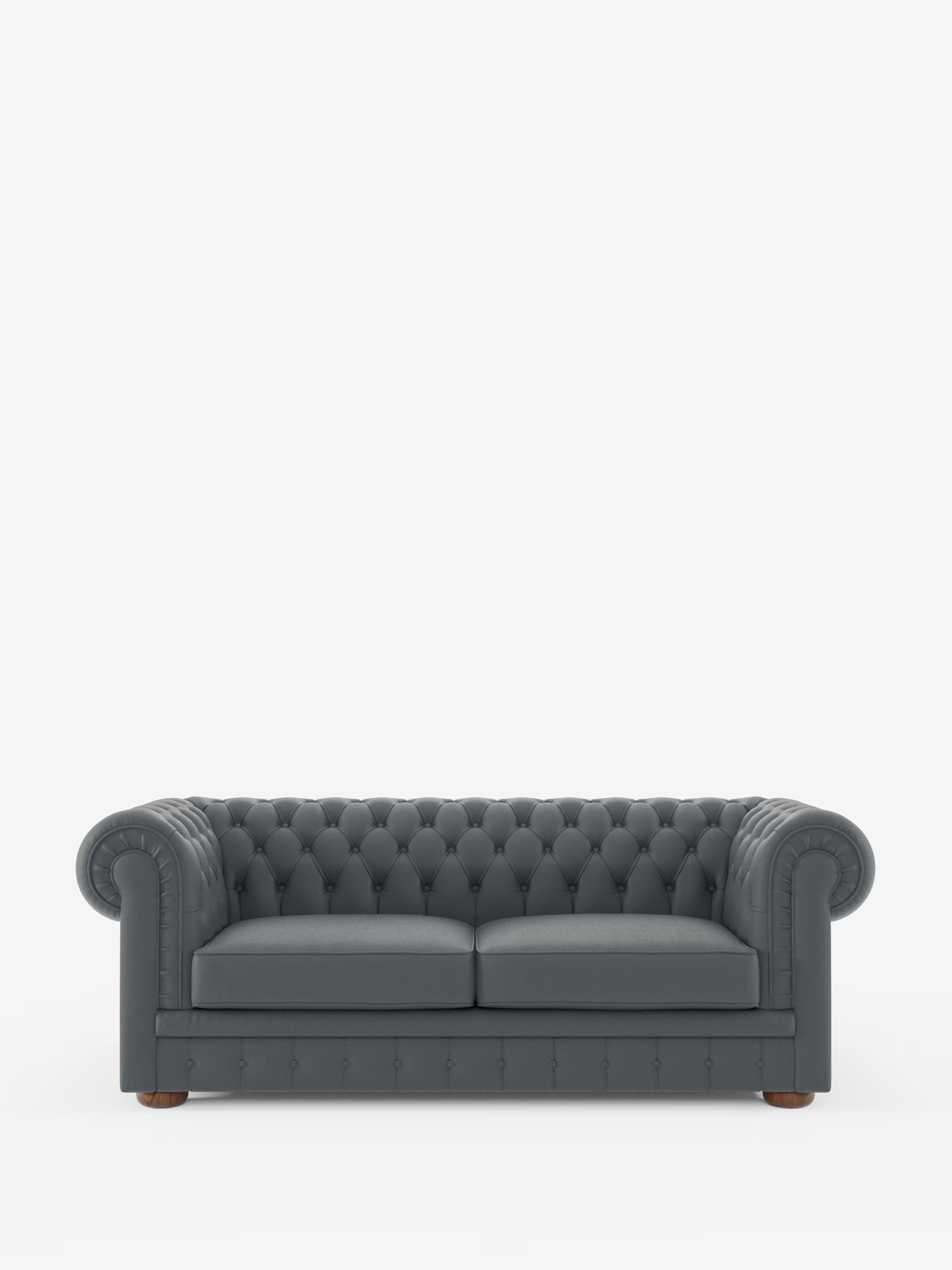 Un Chesterfield grigio scuro – Divano Chesterfield in vera pelle spessorata a 2 e 3 posti di Divani.Store, caratterizzato da braccioli arrotondati, due cuscini di seduta, gambe in legno e profondi dettagli trapuntati con bottoni. Il design classico è rivestito in morbida pelle di prima qualità e si distingue su uno sfondo bianco a tinta unita, per una finitura di lusso.
