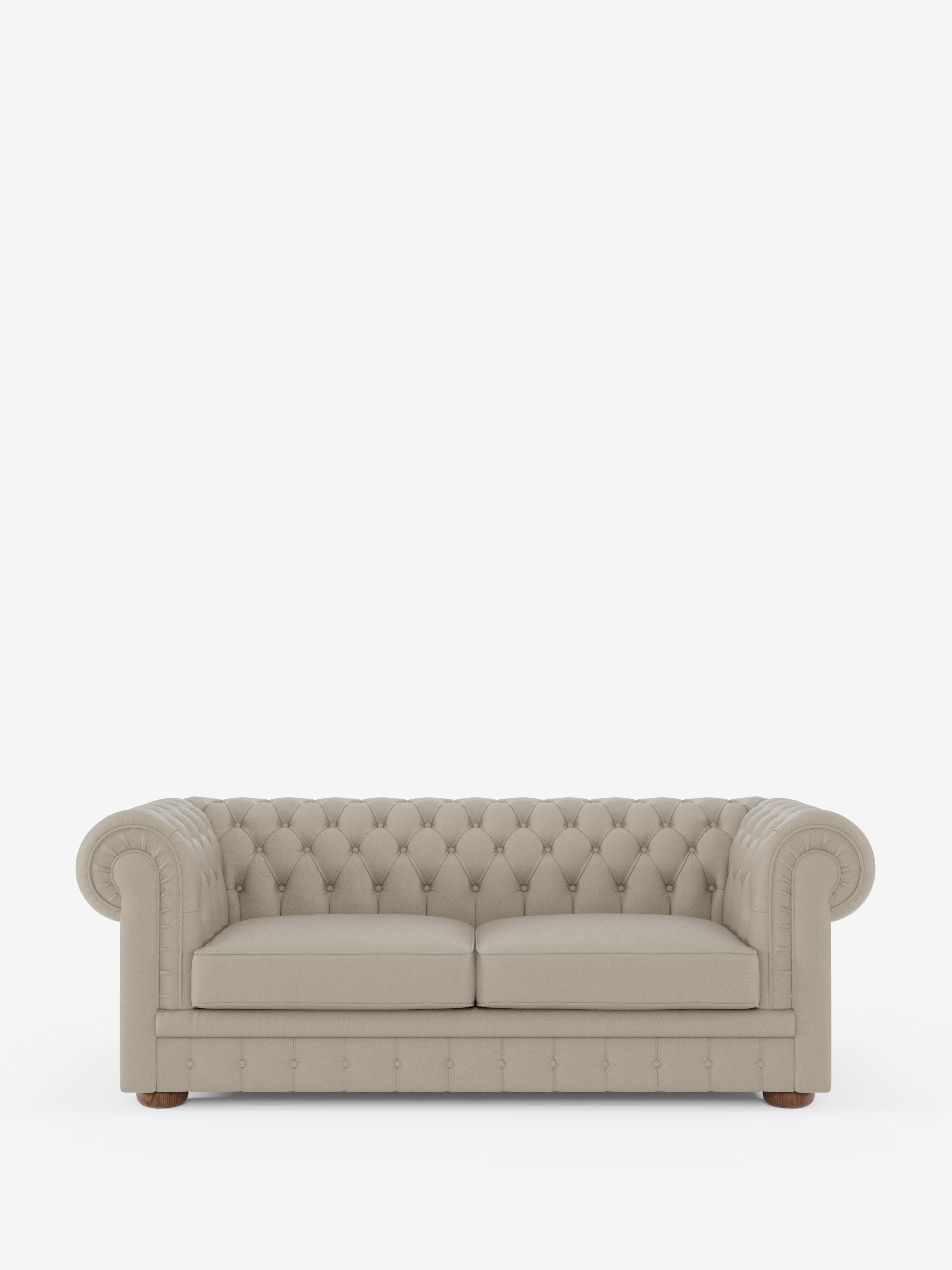 Un divano Chesterfield beige con rivestimento capitonné – Divano Chesterfield in vera pelle spessorata a 2 e 3 posti di Divani.Store, caratterizzato da braccioli arrotondati e due cuscini di seduta, poggia su gambe corte in legno su uno sfondo bianco a tinta unita, mettendo in risalto l’eleganza senza tempo di un divano artigianale Made in Italy.