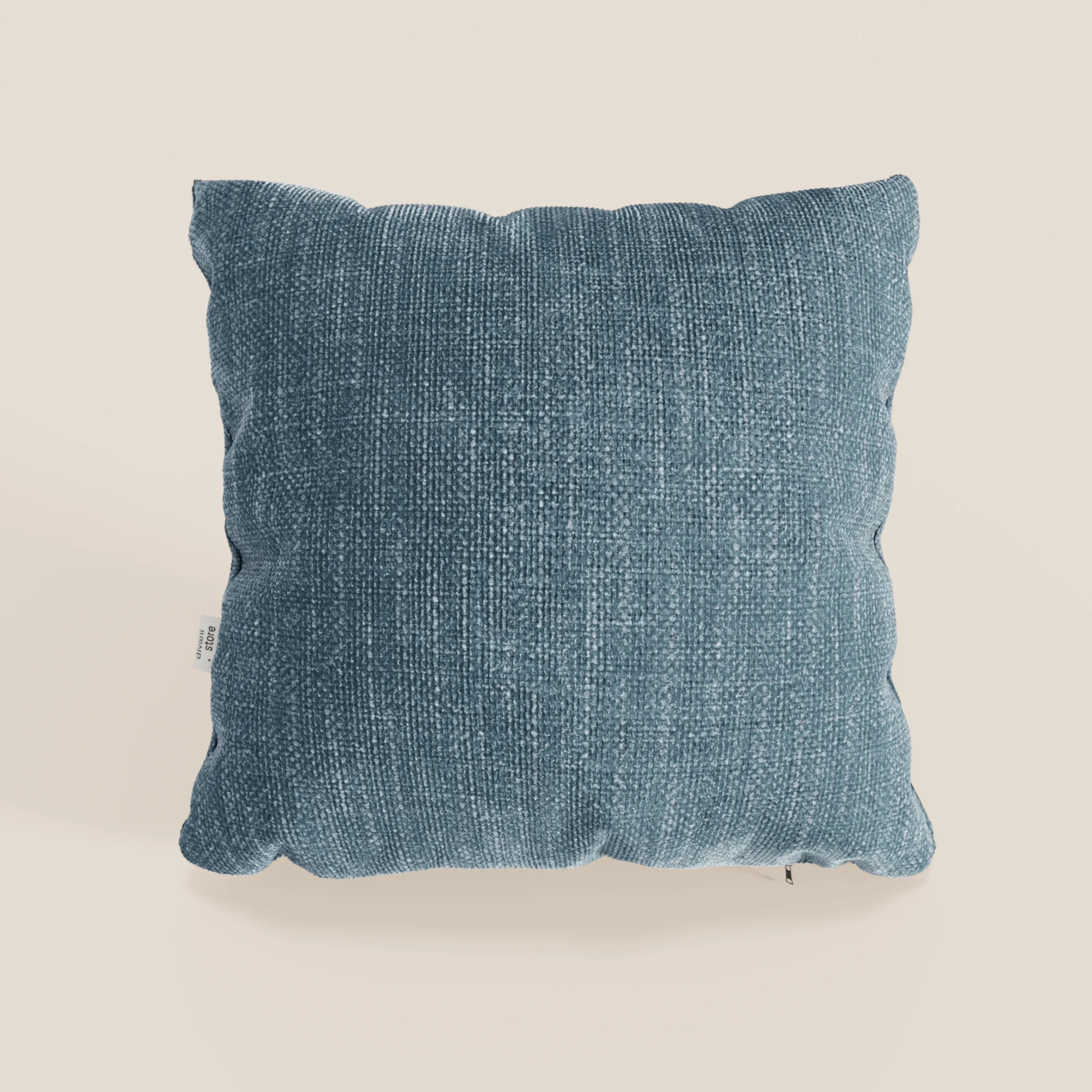 Il cuscino Lyon di Divani.Store in azzurro T06 è caratterizzato da una forma quadrata, da un morbido tessuto impermeabile, da bordi leggermente arrotondati e da una piccola etichetta bianca sulla sinistra su uno sfondo beige chiaro.