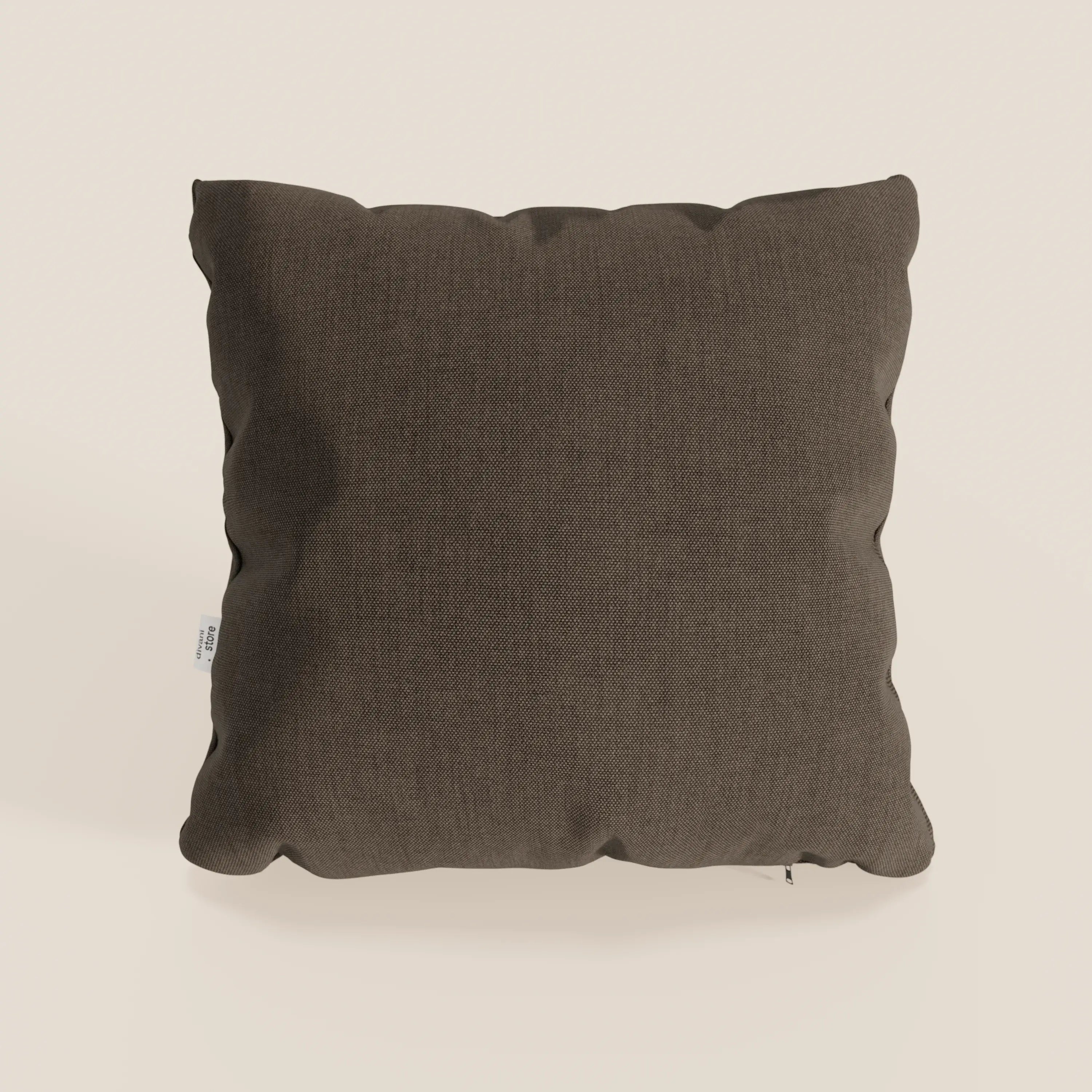 Un cuscino Honey 45x45 cm di Divani.Store, quadrato e di colore marrone scuro, poggia su uno sfondo chiaro. Realizzato in tessuto impermeabile simil cotone T13 marrone, presenta angoli leggermente arrotondati, una texture sottile e una piccola etichetta bianca sulla cucitura sinistra.