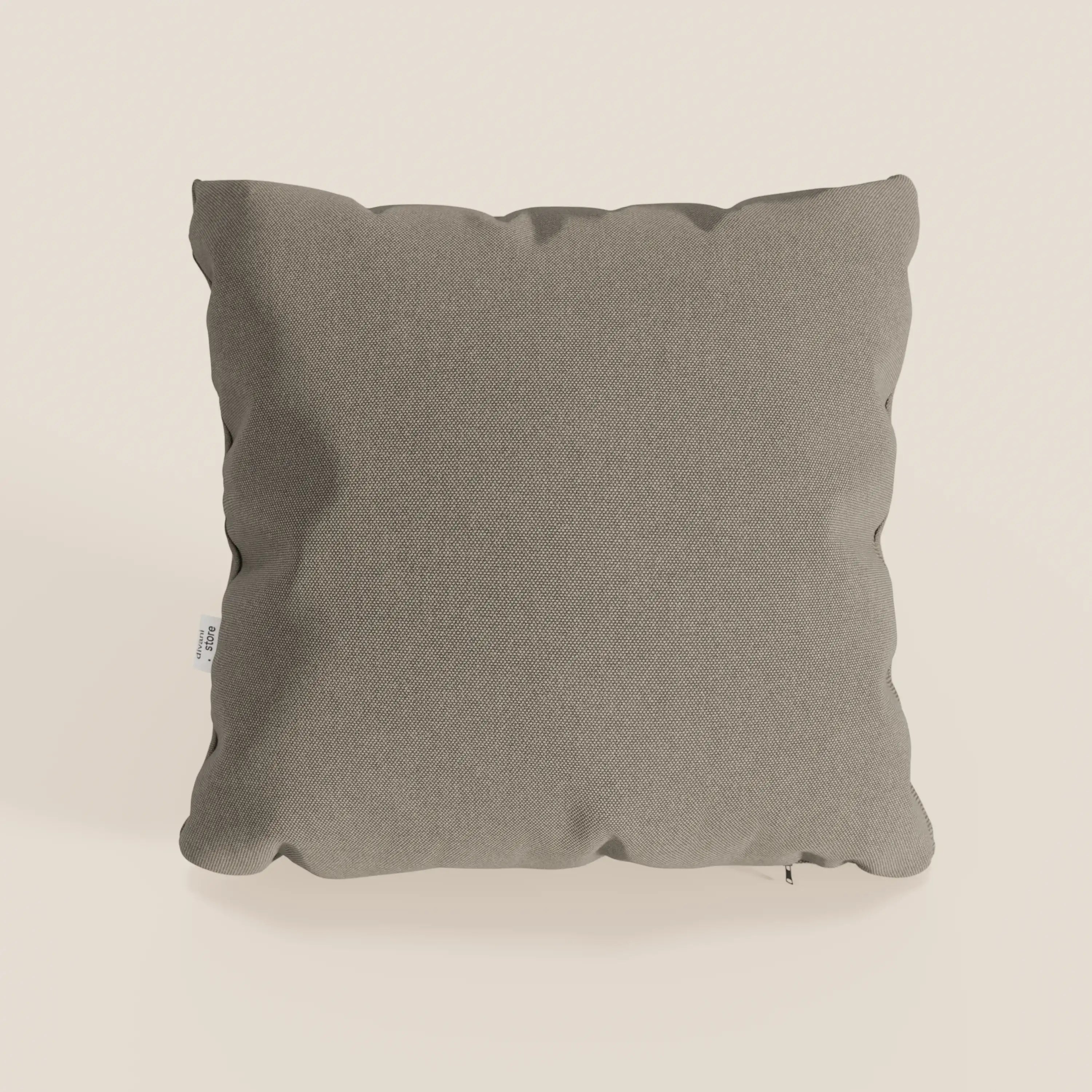 Un cuscino Honey grigio chiaro quadrato 45x45 cm di Divani.Store in tessuto simil cotone impermeabile T13 tortora con bordi leggermente arrotondati e una piccola etichetta bianca si staglia su uno sfondo bianco sporco.