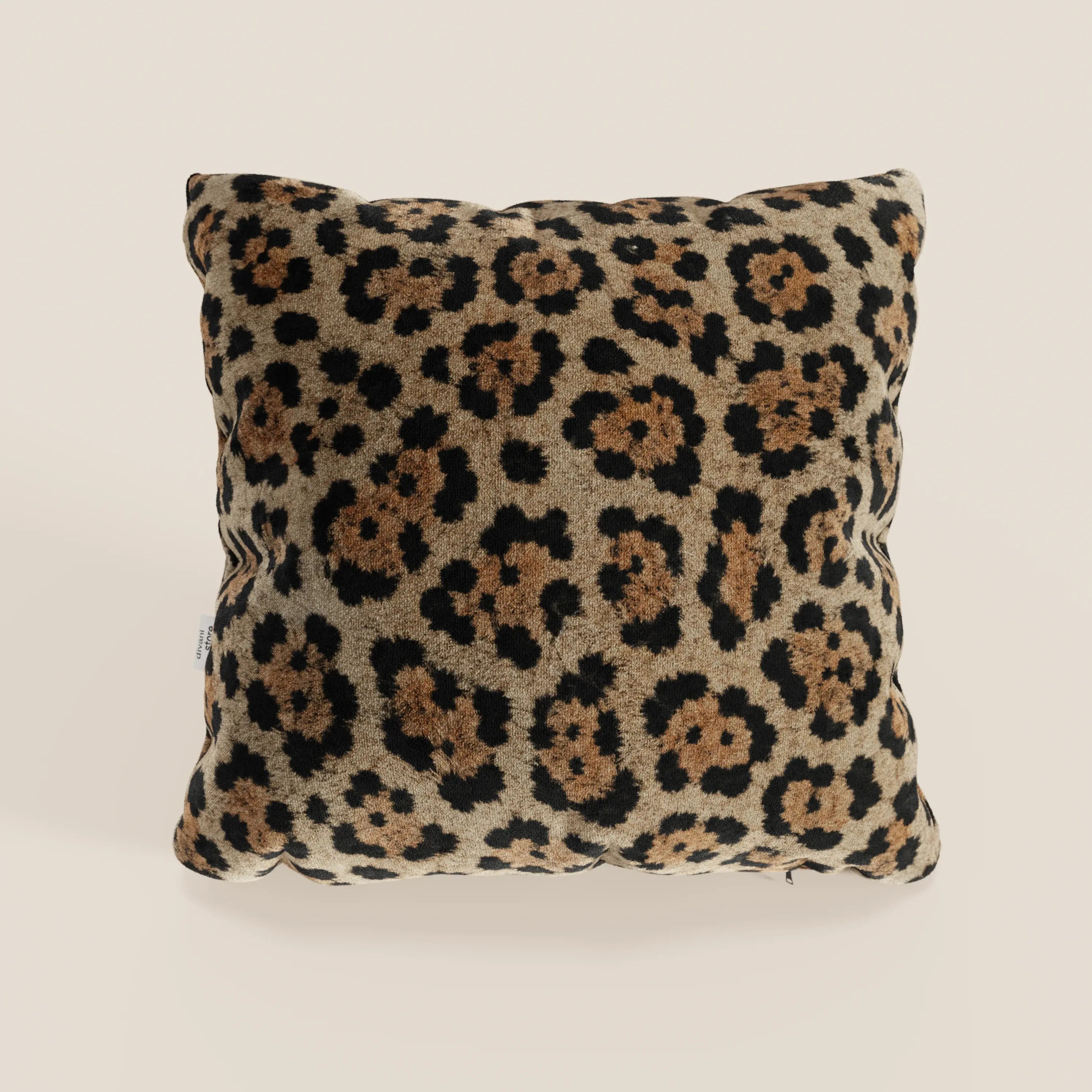 Il cuscino Wild della collezione Wild di Divani.Store è un cuscino quadrato in microfibra impermeabile con un morbido motivo leopardato in nero e marrone su tan, su uno sfondo beige chiaro.