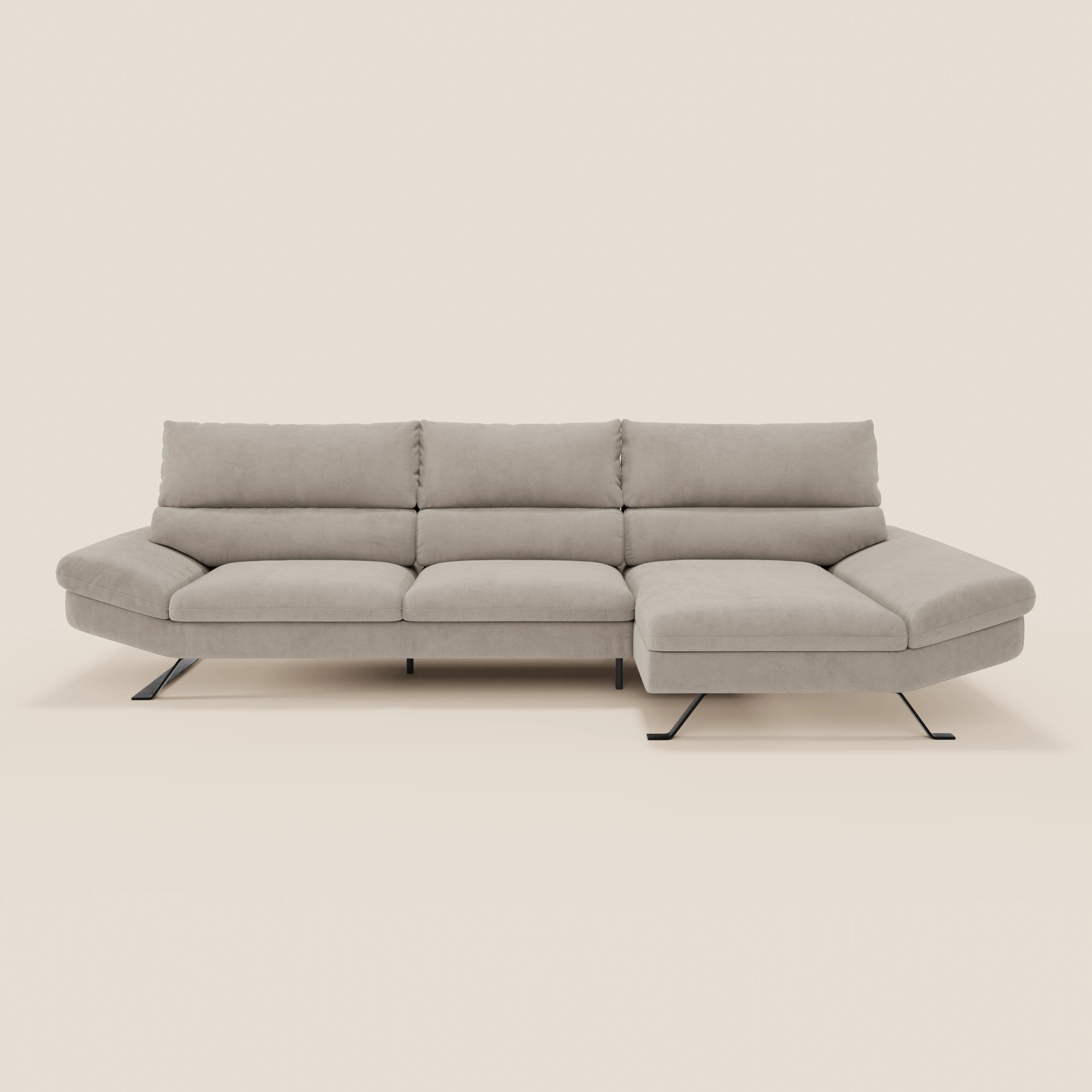 Il divano Eclipse angolare con penisola di Divani.Store è caratterizzato da schienali traslanti, gambe sottili in metallo e microfibra T11 antimacchia in grigio chiaro. La chaise longue orientata a destra è rappresentata su uno sfondo beige.