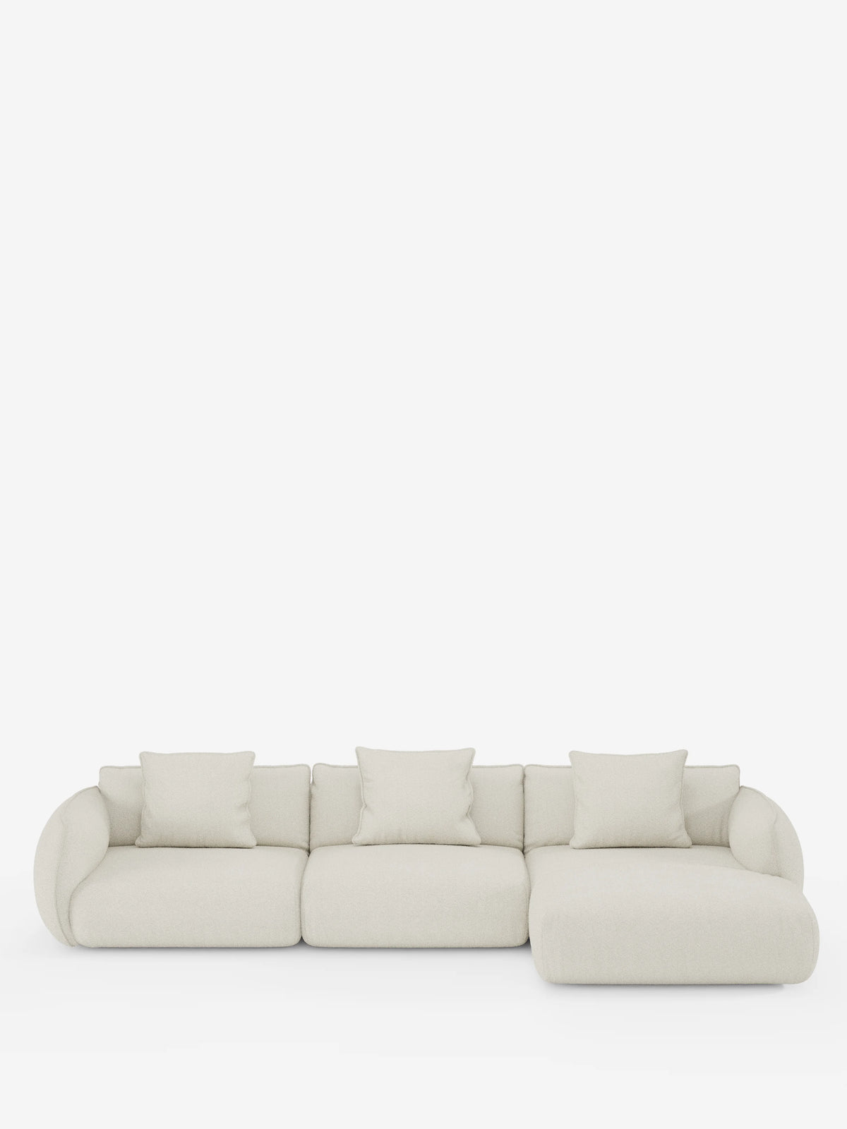 Un divano angolare con penisola componibile Nimbus, dal design contemporaneo e minimalista, firmato Divani.Store, rivestito in tessuto T33 effetto cotone color beige chiaro, antimacchia. Il divano comprende tre sezioni di seduta, quattro cuscini coordinati e una chaise longue sul lato destro (penisola), il tutto presentato su uno sfondo bianco. I bordi arrotondati e il design morbido creano un'estetica accogliente.