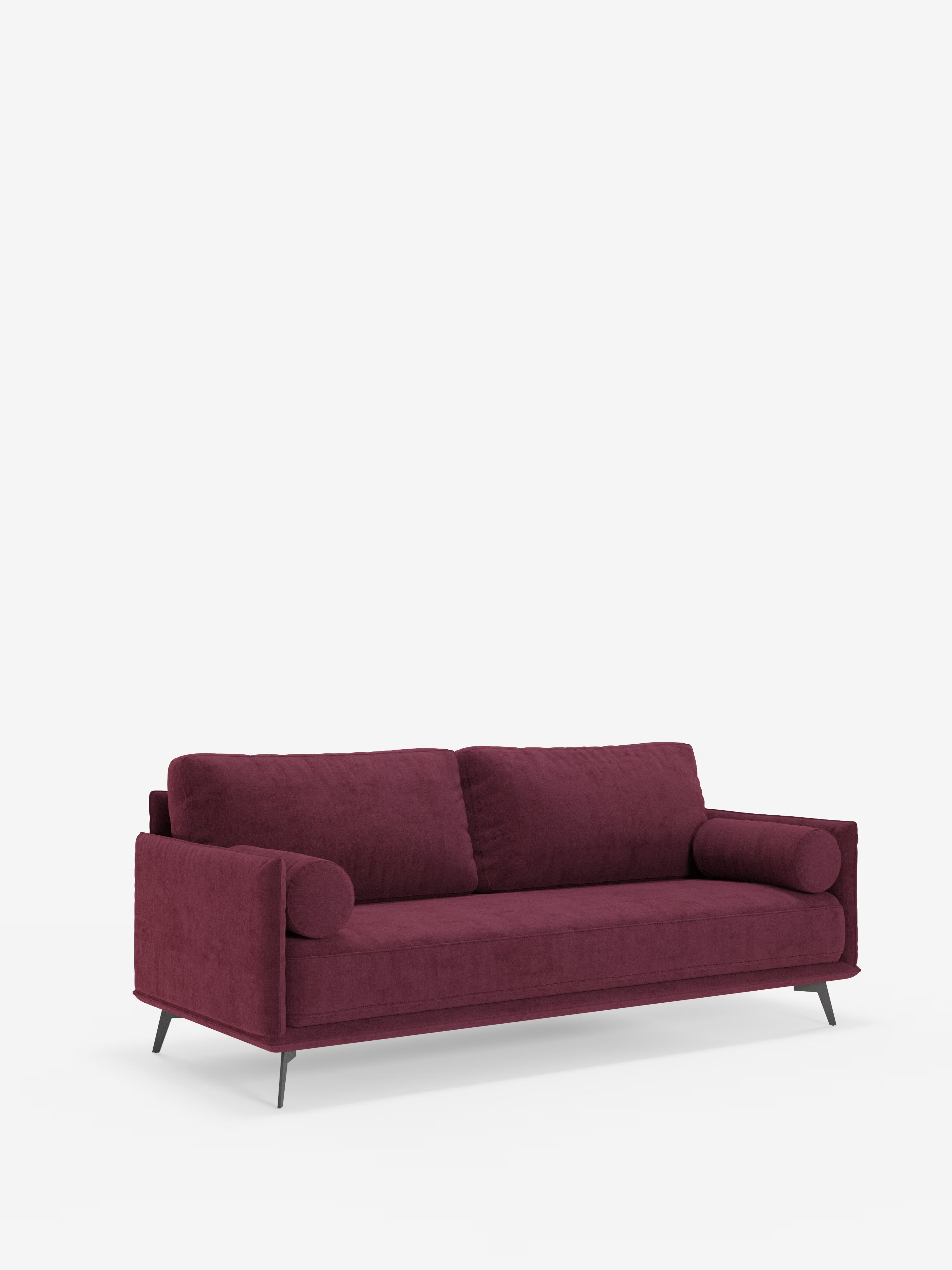 Vi presentiamo il divano lineare Basalto a 2 o 3 posti di Divani.Store, caratterizzato da una silhouette elegante e moderna con un unico ampio cuscino di seduta e linee slanciate. Rivestito in tessuto smacchiabile T31 in una tonalità prugna intenso, presenta braccioli arrotondati e poggia su gambe corte e angolate in metallo nero. Lo sfondo bianco a tinta unita accentua il colore intenso e il design minimalista del divano, incarnando lo stile puro del *divano minimalista*.