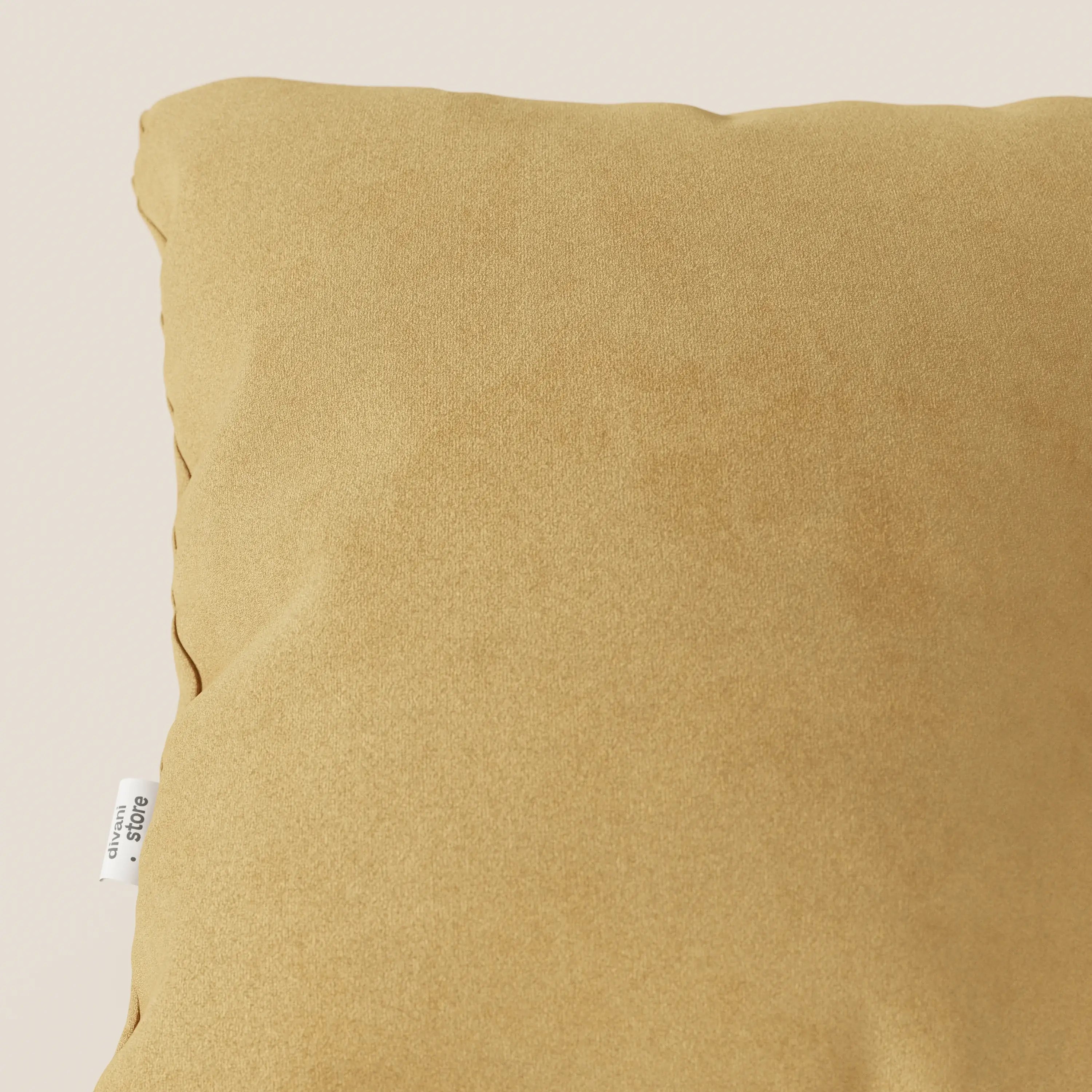 Primo piano del cuscino Jazz di Divani.Store in T11 giallo, realizzato in microfibra tecnica antimacchia, su sfondo beige chiaro con una piccola etichetta bianca visibile sul bordo sinistro.