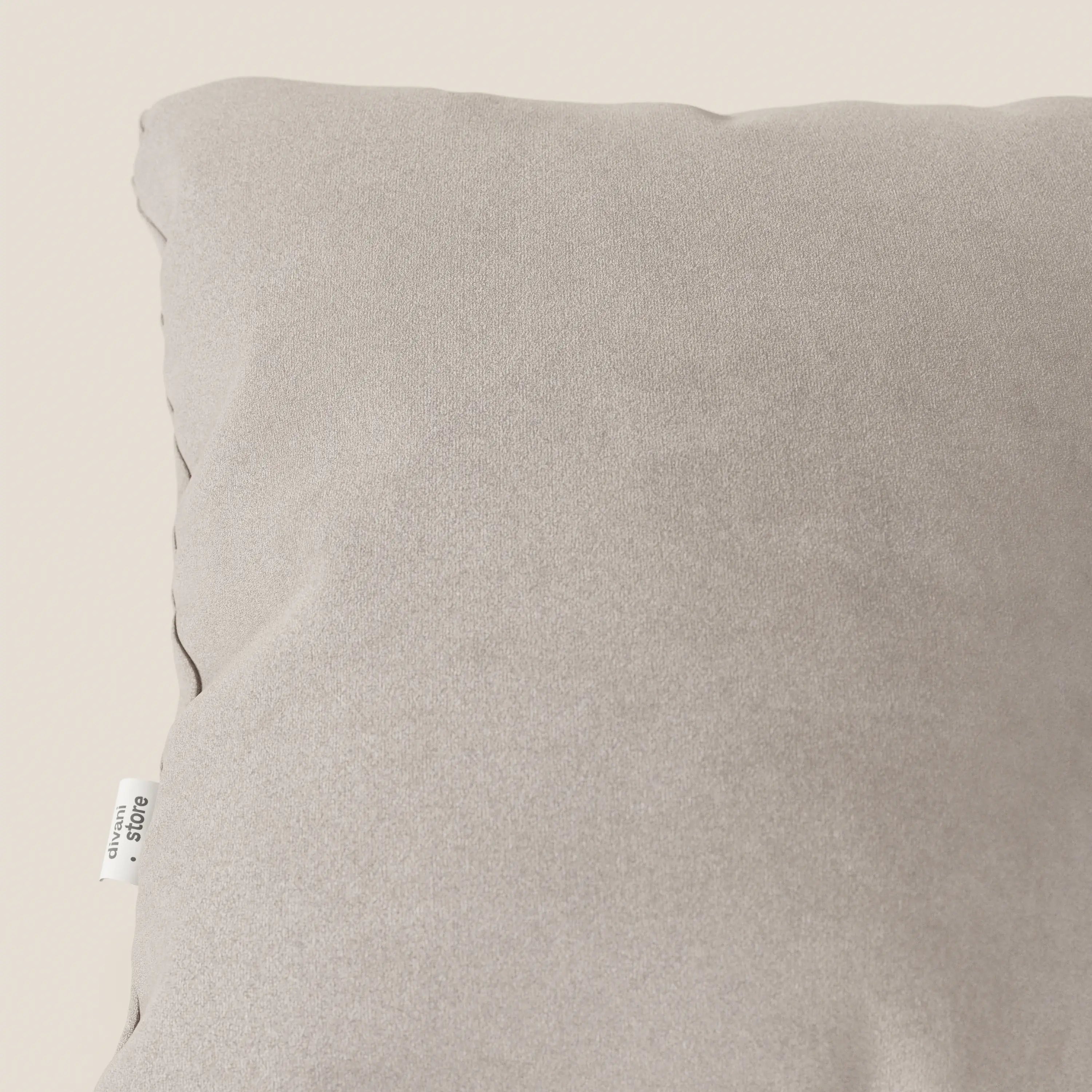 Primo piano dell'angolo superiore sinistro di un cuscino Jazz 45x45 cm in T11 tortora microfibra tecnica smacchiabile di Divani.Store. Una piccola etichetta in tessuto bianco con testo nero è cucita nella cucitura laterale, parzialmente visibile in basso a sinistra.