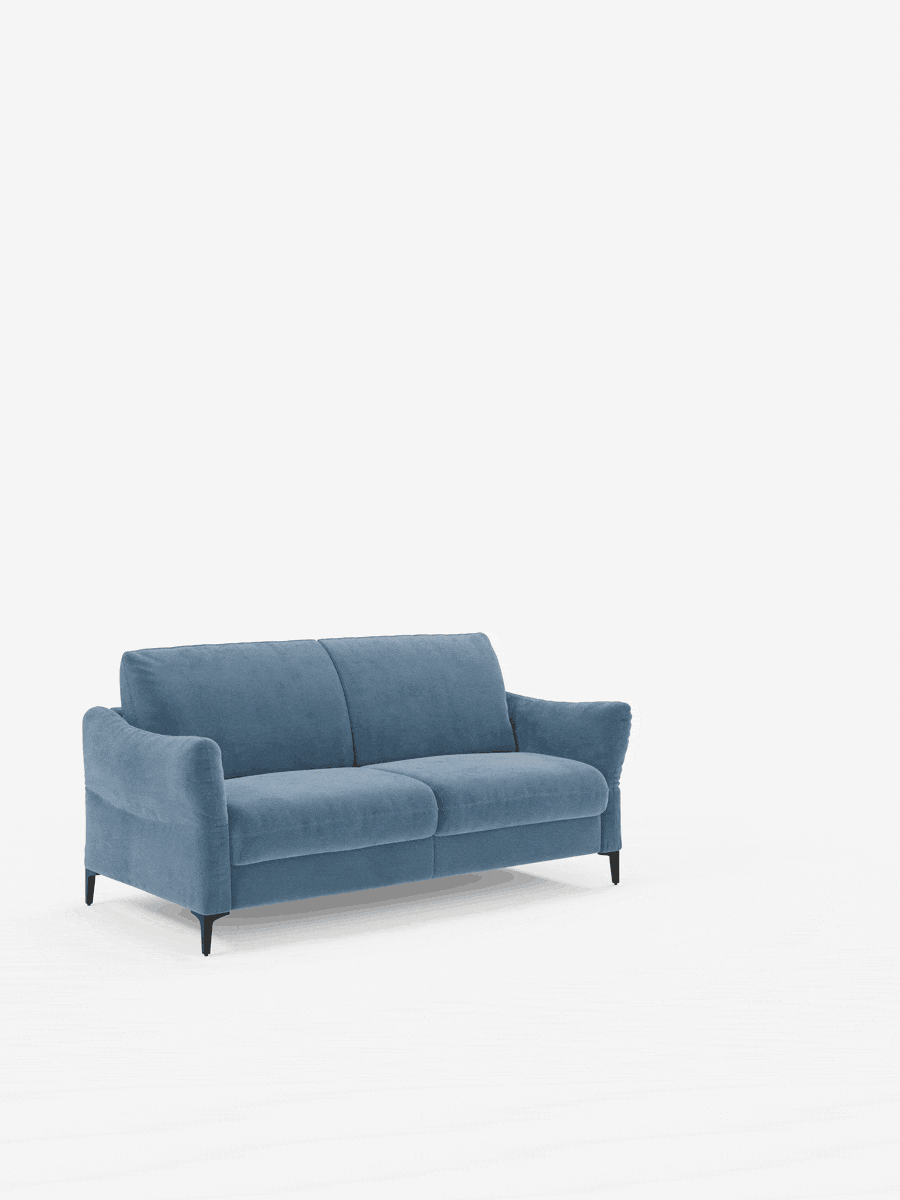 Un moderno divano letto a 2 posti Dalia blu di Divani.Store, rivestito in tessuto di velluto T30 facile da pulire, caratterizzato da morbidi cuscini, braccioli leggermente ricurvi ed eleganti gambe affusolate nere. Il divano letto è posizionato su un pavimento bianco davanti a uno sfondo bianco a tinta unita, mettendo in risalto il suo design elegante e confortevole di ispirazione scandinava, con un materasso alto 18 cm per un comfort ancora maggiore.