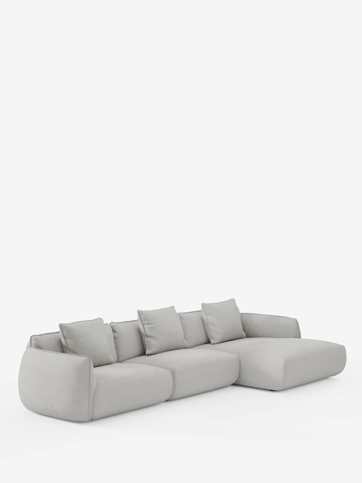 Un moderno divano angolare Nimbus con penisola componibile di Divani.Store, realizzato in tessuto effetto cotone (T33) di colore grigio chiaro, morbido e resistente alle macchie, dotato di quattro cuscini di seduta e cinque cuscini dello schienale coordinati, con bordi delicatamente arrotondati e una chaise longue estesa sul lato destro, su uno sfondo bianco a tinta unita.