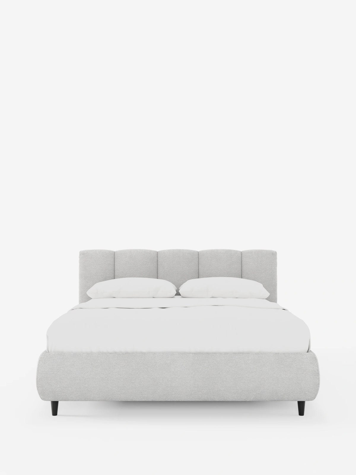 Il letto imbottito ARKAM con contenitore e testiera a cuciture verticali è un letto di colore grigio chiaro con testiera a cuciture verticali, biancheria da letto di un bianco brillante e gambe corte, affusolate e di colore scuro che risaltano sullo sfondo bianco.
