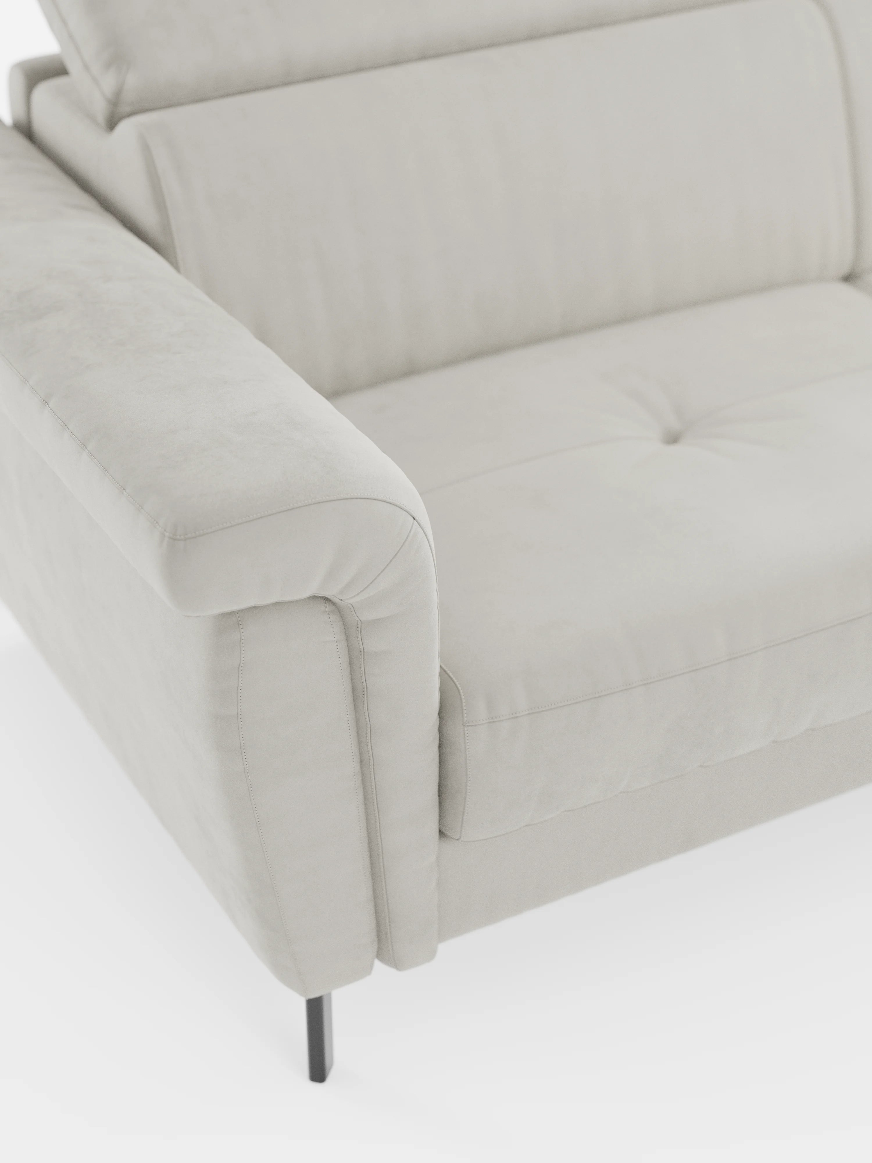 Primo piano del divano letto di design Capri di Divani.Store, realizzato in tessuto effetto velluto smacchiabile T30 grigio chiaro, caratterizzato da braccioli imbottiti, cuscino di seduta trapuntato, gambe alte e slanciate in metallo nero e poggiatesta regolabile su sfondo bianco. Lo stile minimalista e contemporaneo esalta la raffinata manifattura italiana.