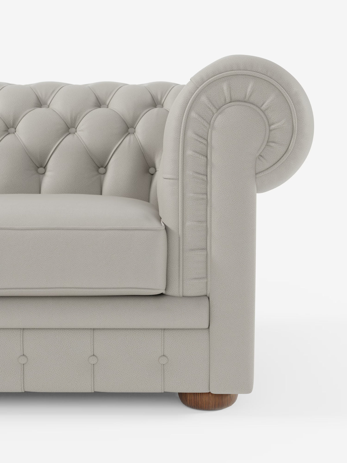 Primo piano del bracciolo destro del divano Chester 4 Posti 3 sedute in vera pelle – Chesterfield Capitonné Artigianale di Divani.Store, caratterizzato da bracciolo arrotondato, schienale e parte anteriore trapuntati con bottoni, piedini rotondi in legno e cuscini morbidi. Questo elegante divano Chesterfield realizzato a mano in Italia è ripreso su uno sfondo bianco a tinta unita.