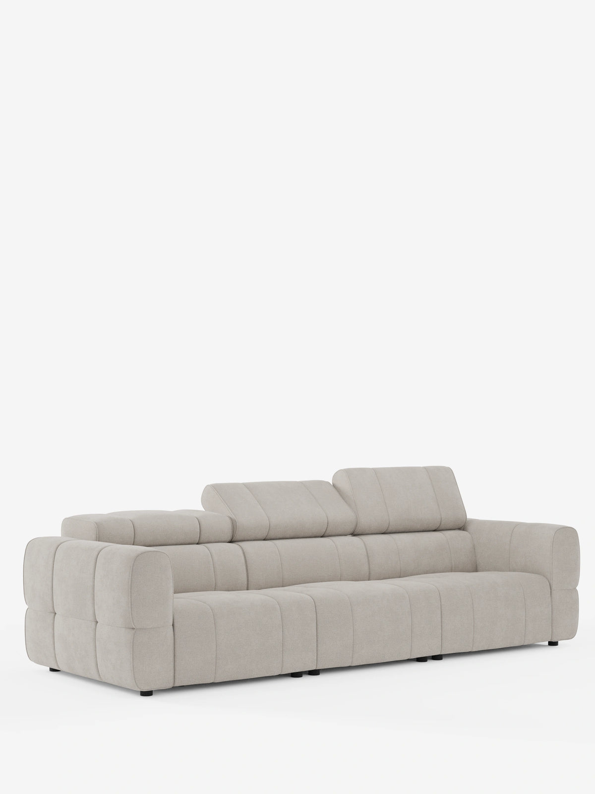 Un divano modulare contemporaneo “Giotto” a 4 posti con poggiatesta reclinabili e funzione relax elettrica opzionale, rivestito in tessuto smacchiabile T23 color beige chiaro, caratterizzato da un design trapuntato con due poggiatesta regolabili e braccioli bassi e squadrati.