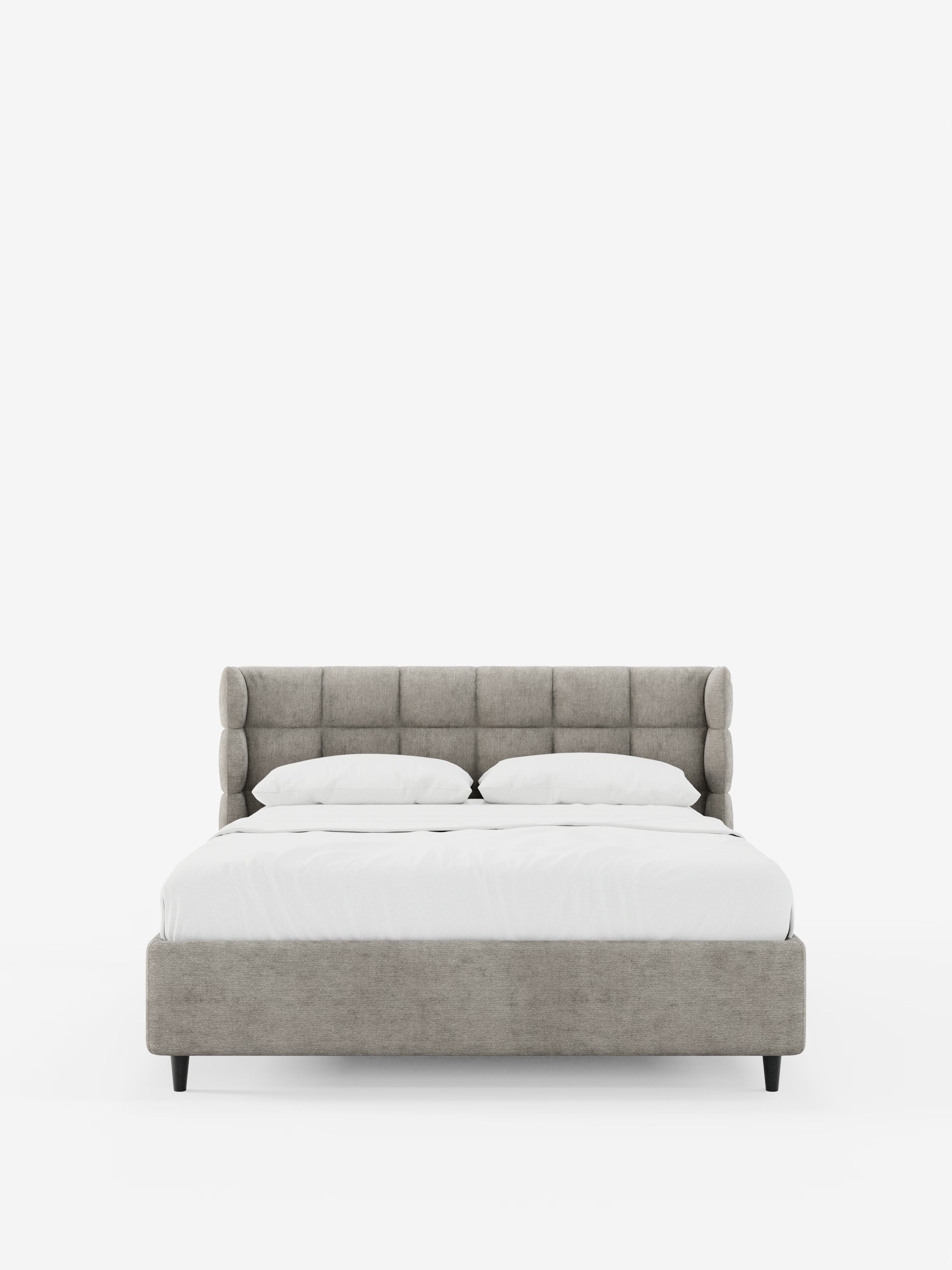 Il letto imbottito contemporaneo RAGNAR con contenitore e testiera capitonné avvolgente di Letti.store è ripreso in una vista frontale, con testiera e struttura imbottite in grigio chiaro certificate Oeko-Tex®, due cuscini bianchi e un piumone bianco disposto con cura. Il letto poggia su corte gambe nere su uno sfondo bianco a tinta unita.