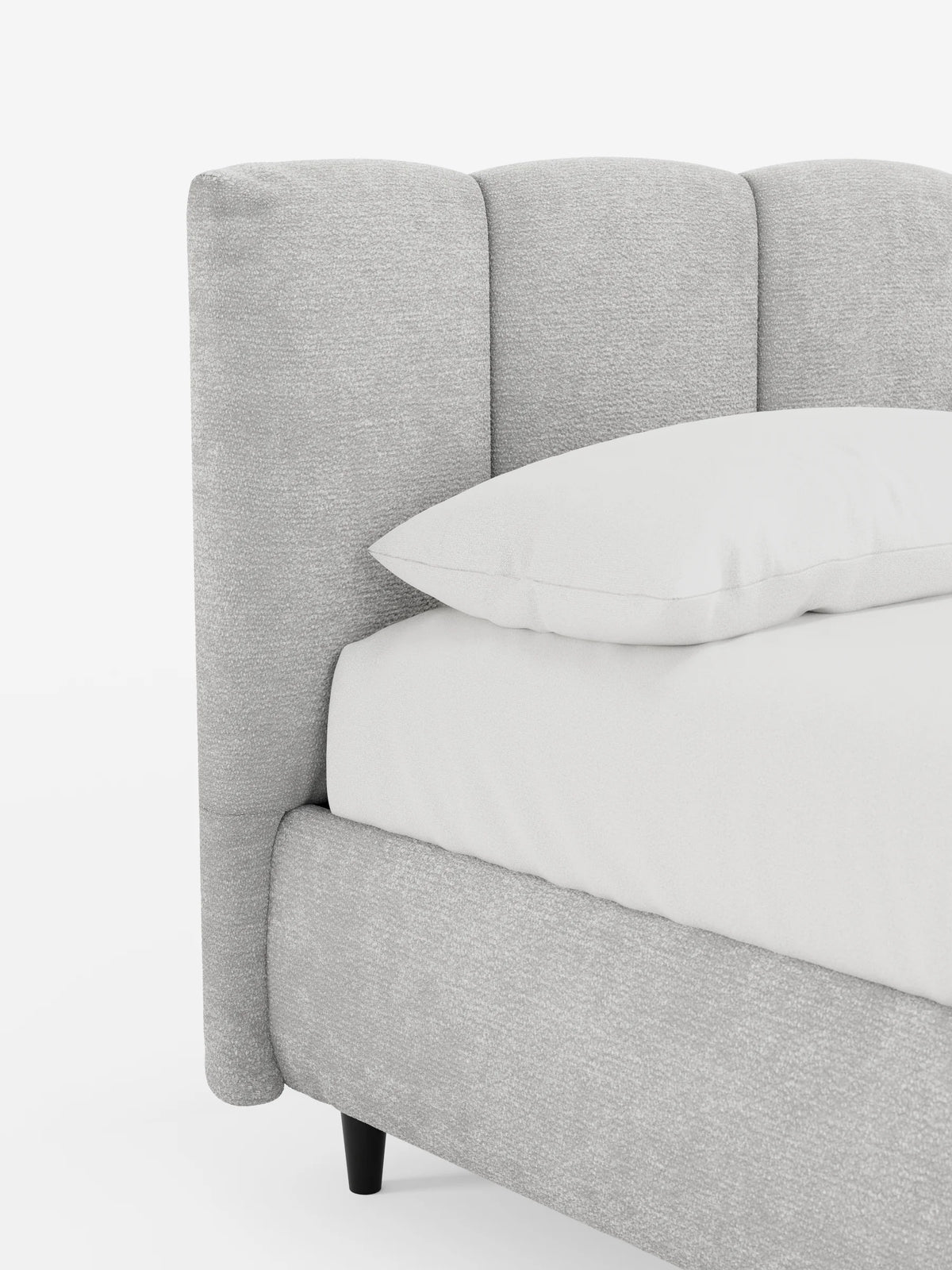 Il letto imbottito ARKAM con contenitore e testiera a cuciture verticali è un letto imbottito di colore grigio chiaro con una testiera alta dalle cuciture verticali, un cuscino bianco e un lenzuolo con angoli, appoggiato su gambe scure su uno sfondo bianco.