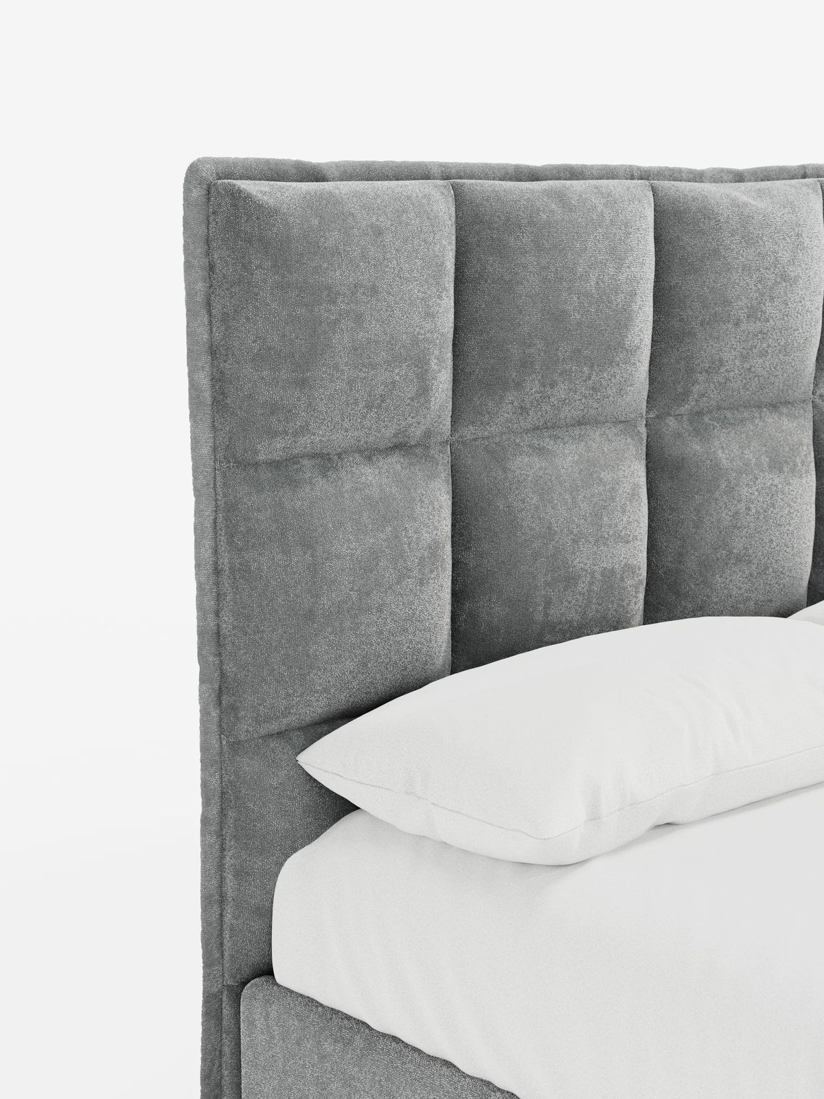 Primo piano del letto imbottito AURO di Letti.store, caratterizzato da una testiera alta e imbottita con un’elegante trapuntatura capitonné. Il rivestimento in tessuto ciniglia certificato Oeko-Tex® appare morbido e ricco di texture. Si intravedono parzialmente un cuscino e un materasso bianchi, che mettono in risalto le linee pulite e i toni neutri del letto. Lo sfondo bianco a tinta unita sottolinea il design moderno e minimalista.