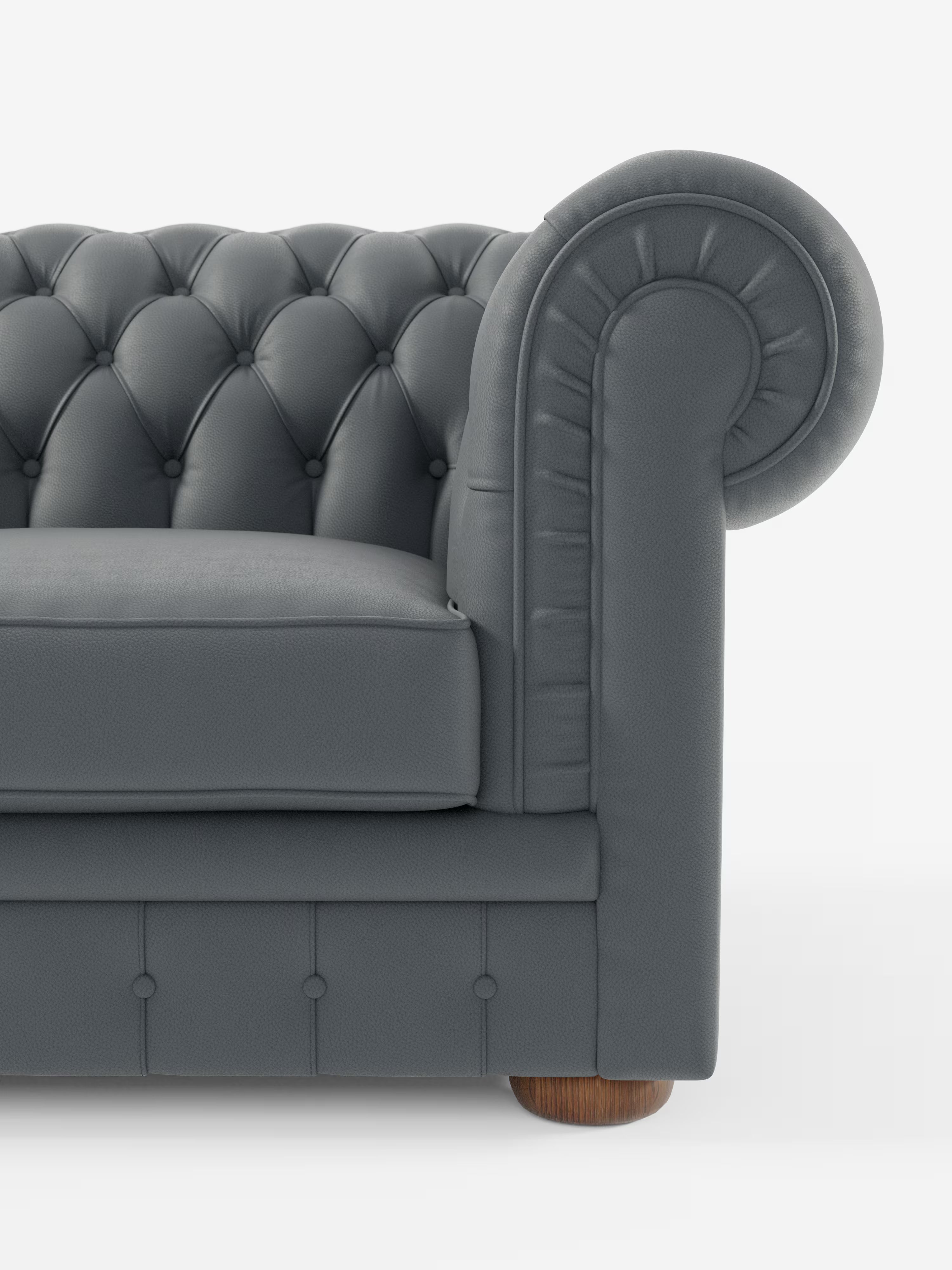 Primo piano del lato sinistro di un divano Chesterfield grigio scuro – Divano Chesterfield in vera pelle spessorata a 2 e 3 posti di Divani.Store, caratterizzato da braccioli ricurvi, bottoni profondi e gambe arrotondate in legno, su uno sfondo bianco a tinta unita.