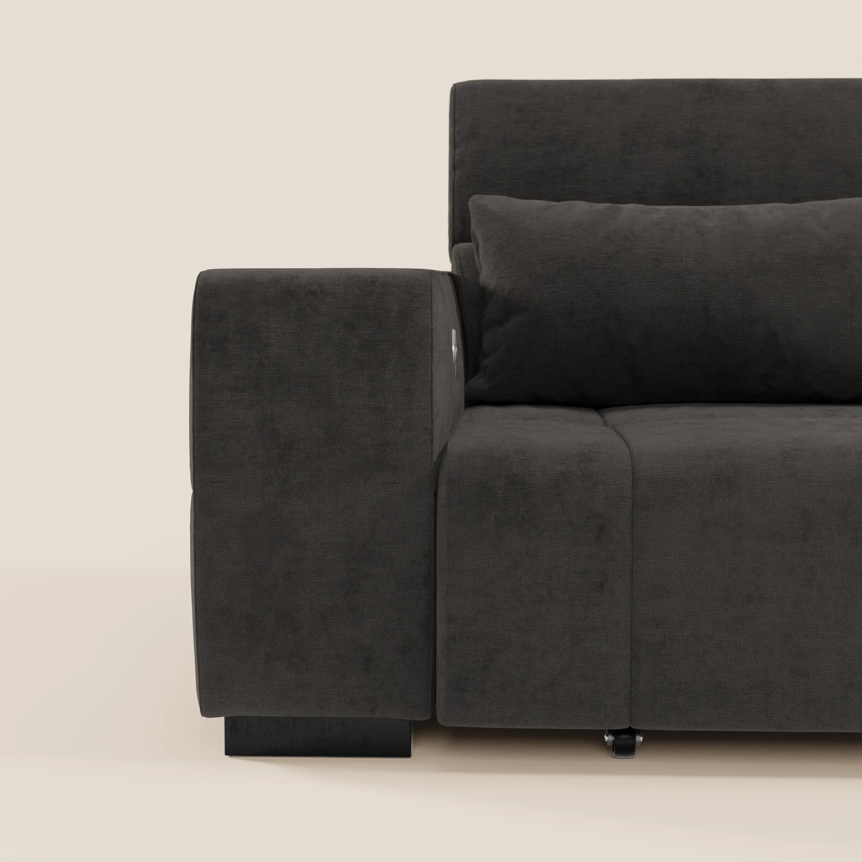 Primo piano del Monarch Divano con Relax Elettrico di Divani.Store, in tessuto smacchiabile T31 grigio scuro, con ampio bracciolo e cuscino coordinato. Su uno sfondo beige chiaro, sono visibili solo il lato sinistro e la seduta.