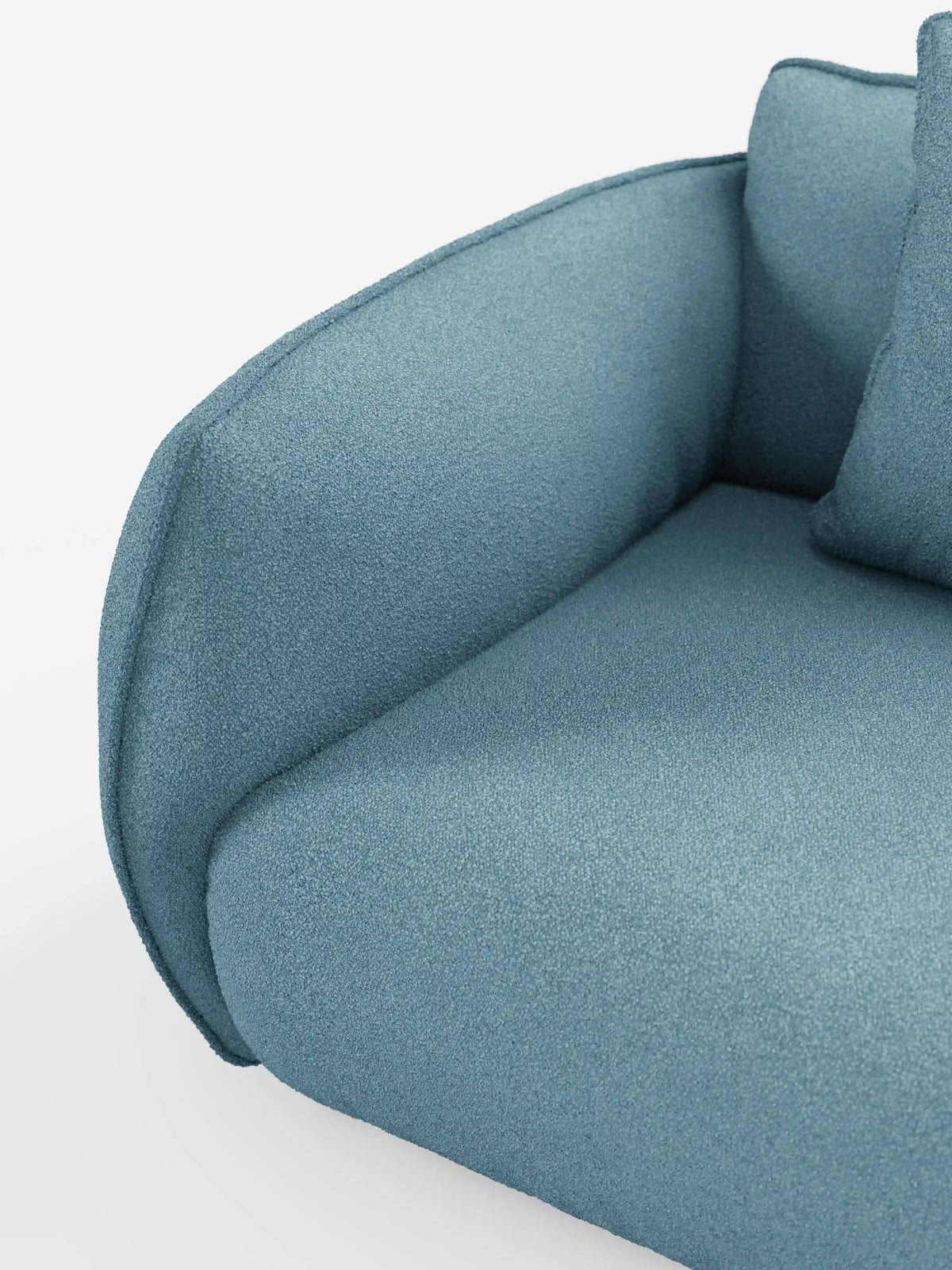 Primo piano del divano modulare a 3 posti “Nimbus” di Divani.Store, rivestito in morbido tessuto T33 effetto cotone, resistente alle macchie, in colore blu. L’immagine mette in risalto il bracciolo ricurvo, il cuscino della seduta e parte di un cuscino dello schienale su uno sfondo bianco, sottolineando il design elegante e minimalista del divano.