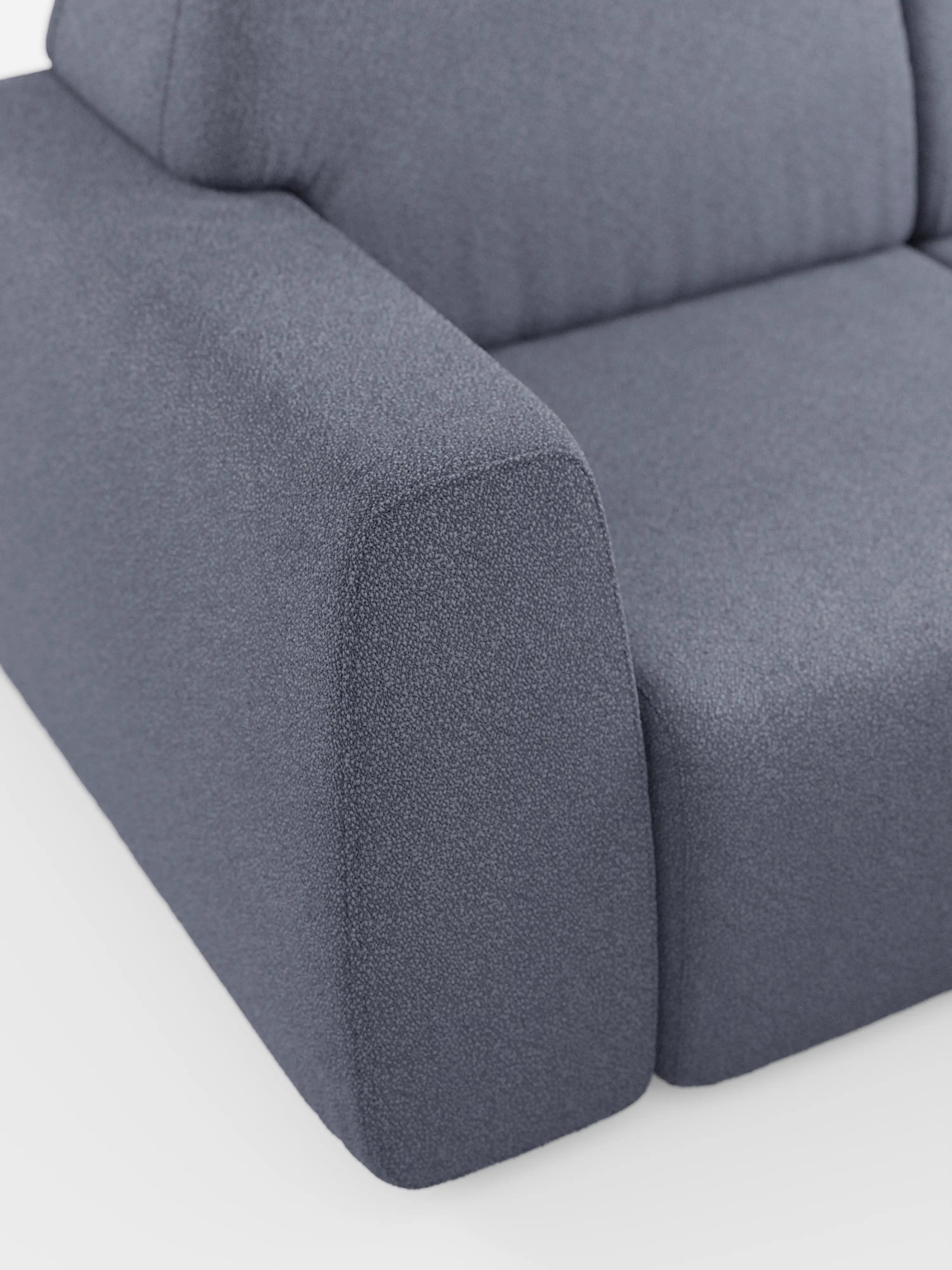 Primo piano del divano angolare Orbit con penisola reversibile e tutte le sedute allungabili di Divani.Store, rivestito in morbido tessuto T33 effetto cotone, resistente alle macchie, in grigio testurizzato. L'immagine mette in risalto l'ampio bracciolo, la seduta e lo schienale imbottiti con bordi puliti e arrotondati e cuciture minime, su uno sfondo bianco.