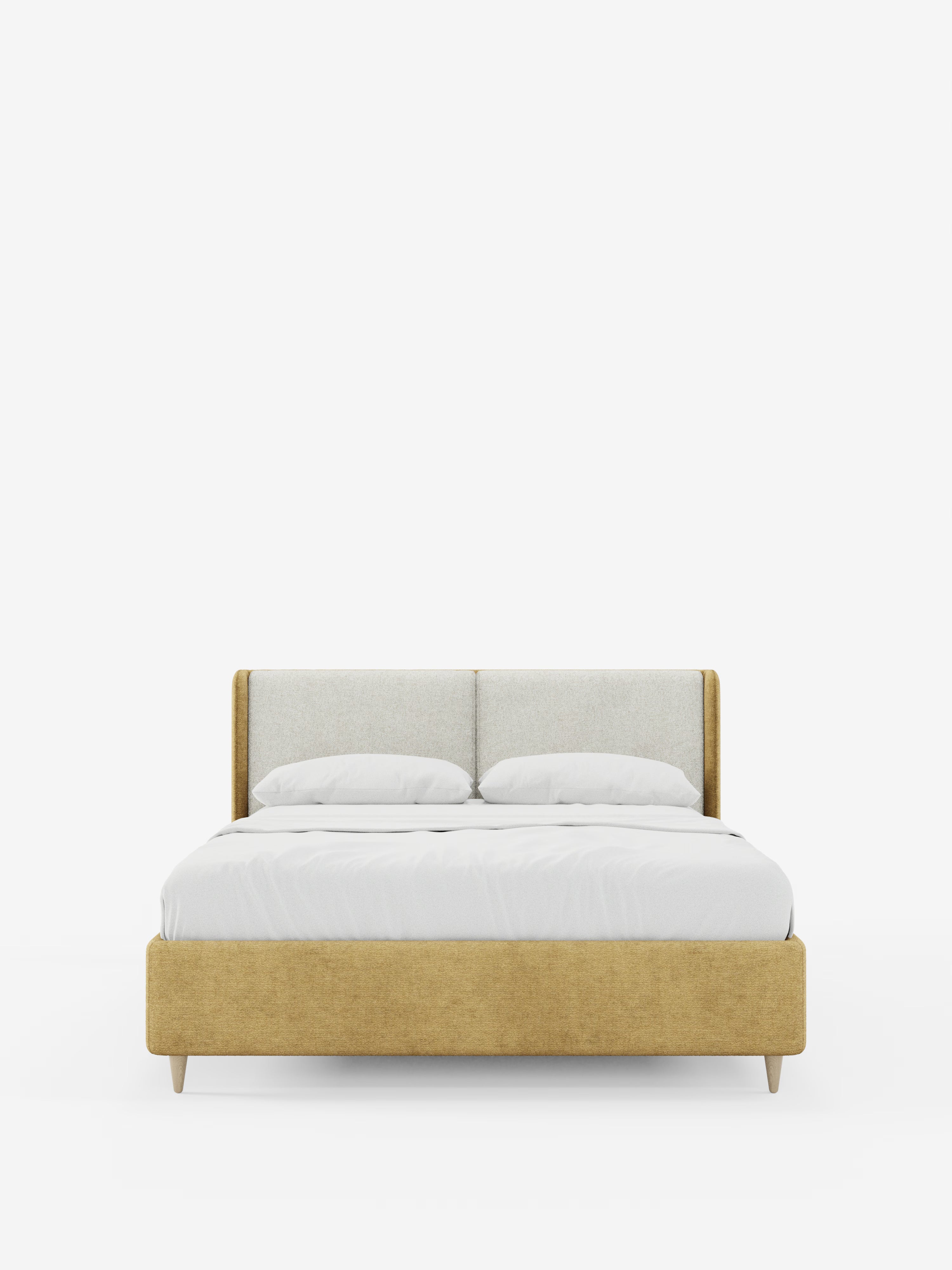 Il letto imbottito bicolore VALKIRIA con contenitore di Letti.store presenta una moderna struttura imbottita color giallo senape, una testiera imbottita leggermente ricurva con cuscini coordinati e due cuscini bianchi. La biancheria da letto bianca a tinta unita è completata da quattro gambe corte e angolate in legno, il tutto su un semplice sfondo bianco.