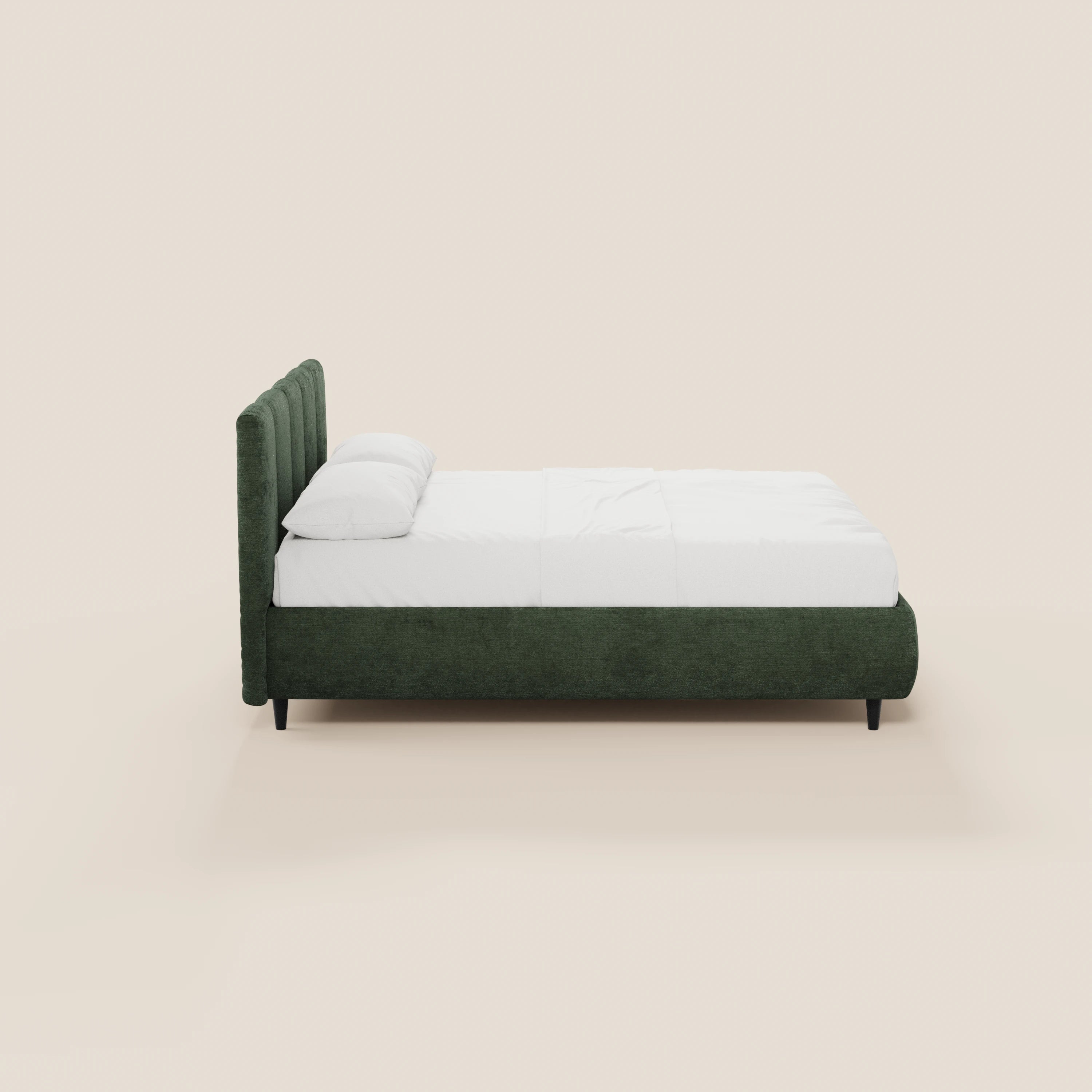 Vista laterale del letto imbottito ARKAM di Letti.store, caratterizzato da un tessuto verde scuro certificato Oeko-Tex®, una testiera alta con cuciture verticali, biancheria da letto bianca con due cuscini e gambe nere. Questo letto in stile shabby chic è dotato di un vano contenitore.
