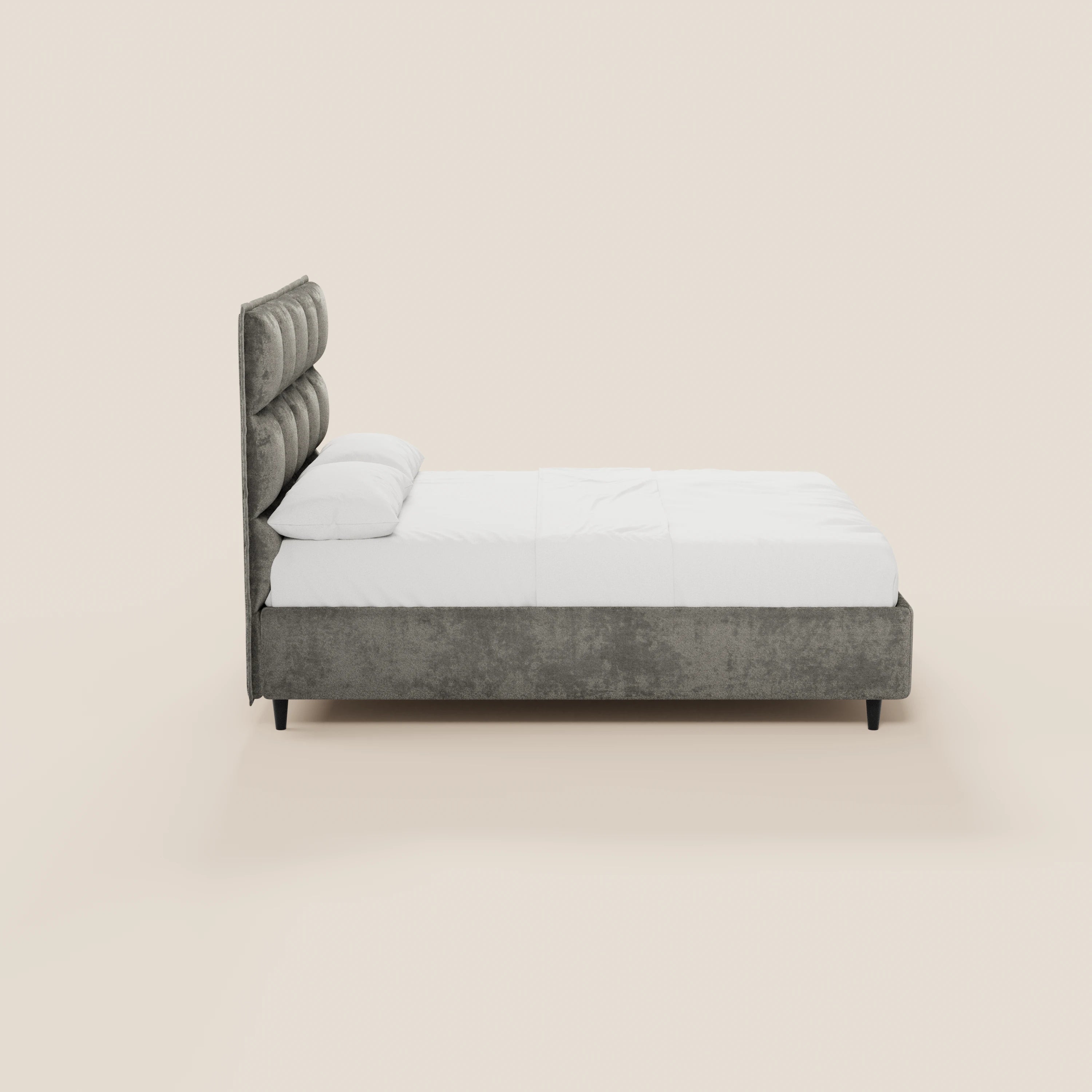 Vista laterale del letto imbottito AURO con contenitore e testiera alta capitonné in ciniglia Oeko-Tex® di Letti.store, con biancheria da letto bianca e gambe corte nere, su uno sfondo beige chiaro.