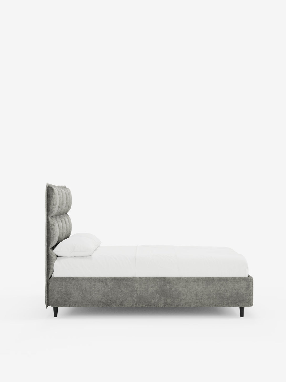 Vista laterale del letto imbottito AURO con vano contenitore e testiera alta capitonné in ciniglia Oeko-Tex® di Letti.store, caratterizzato da una testiera alta imbottita in capitonné grigio, biancheria da letto bianca e una base in tessuto grigio. Il letto poggia su gambe nere ed è posizionato su uno sfondo bianco a tinta unita. Sul lato sinistro del letto è visibile un cuscino bianco.