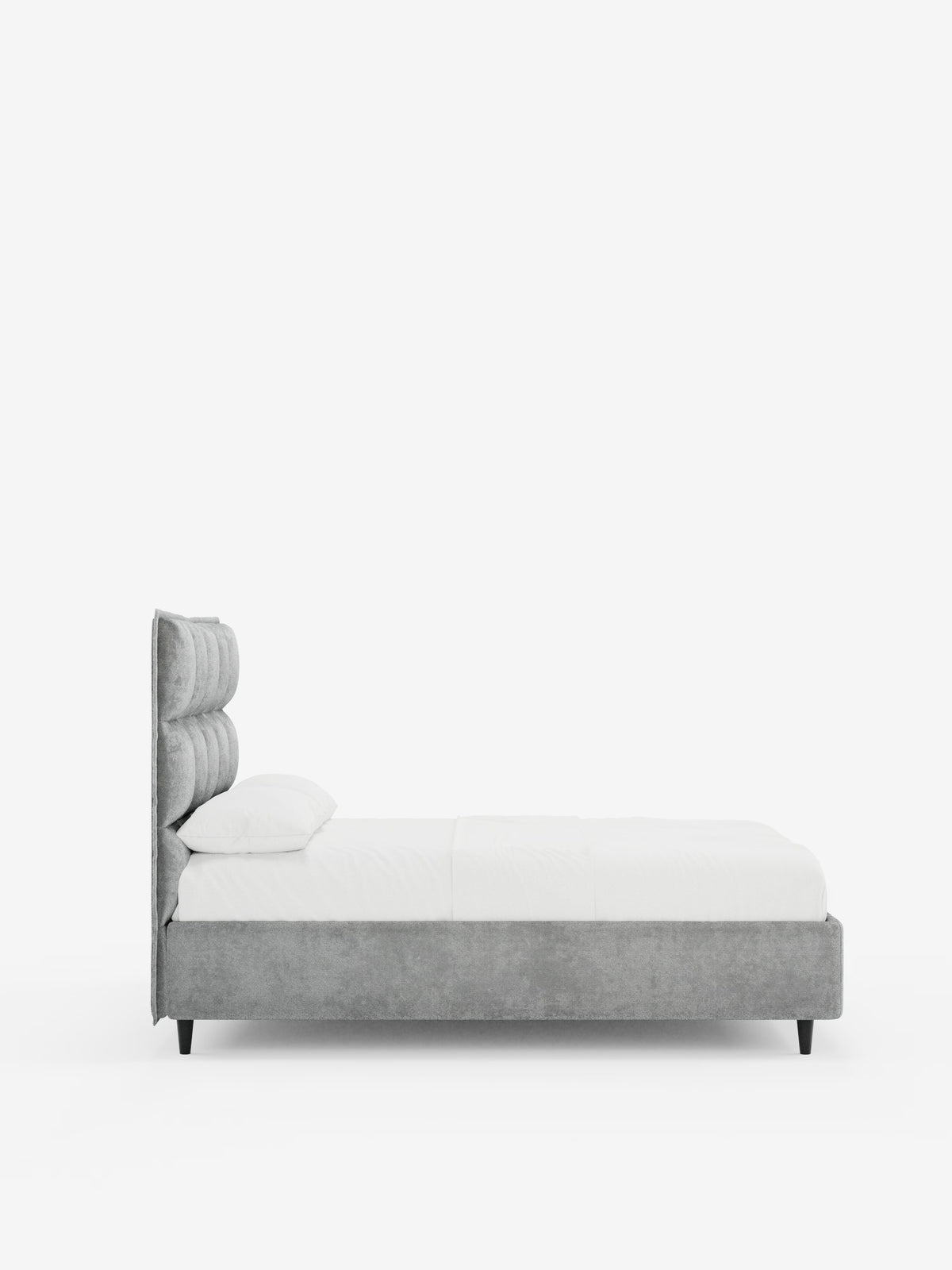 Vista laterale del letto imbottito AURO con contenitore e testiera capitonné alta in ciniglia Oeko-Tex® di Letti.store, caratterizzato da una testiera alta imbottita grigia con capitonné, biancheria da letto bianca e una struttura grigia dal profilo basso con gambe corte nere, il tutto su uno sfondo bianco a tinta unita.
