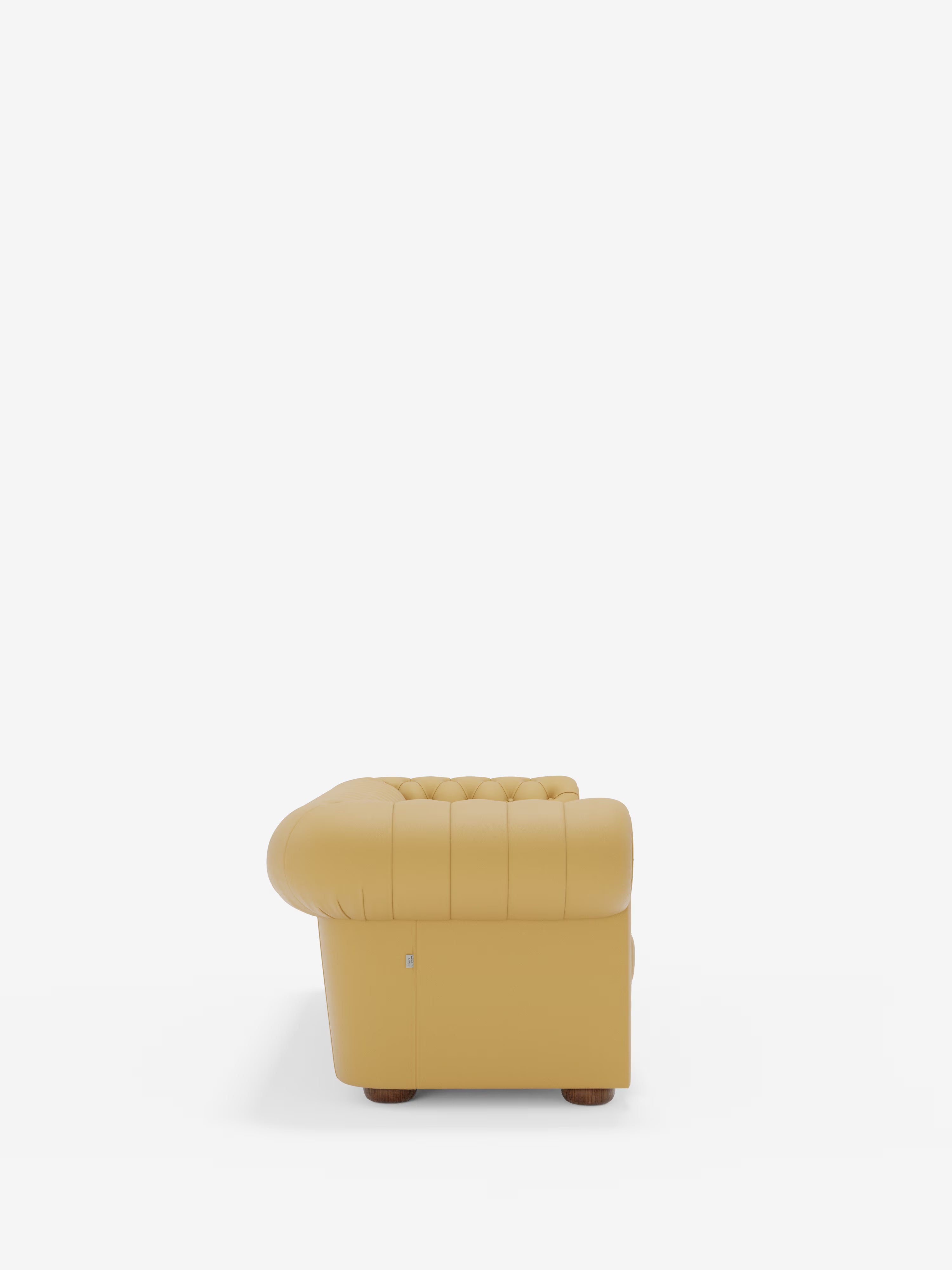 Il Chester – Divano Chesterfield in vera pelle spessorata a 2 e 3 posti di Divani.Store è raffigurato di profilo su uno sfondo bianco a tinta unita, che ne mette in risalto lo schienale trapuntato e i braccioli arrotondati. Questo divano artigianale Made in Italy poggia su gambe corte in legno.