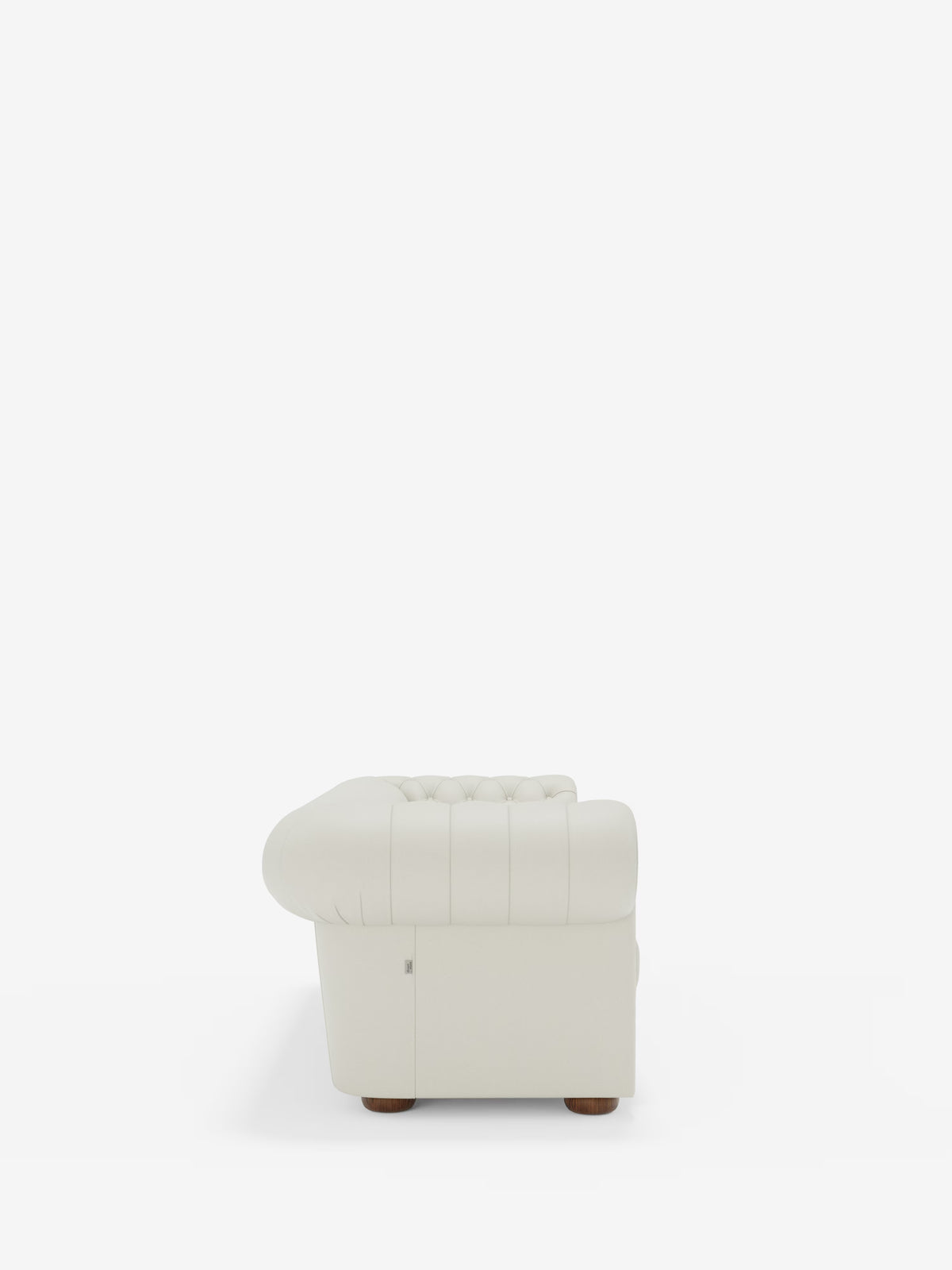 Vista laterale del Chester 4 Posti 3 sedute in Vera Pelle – Chesterfield Capitonné Artigianale di Divani.Store, un divano bianco realizzato artigianalmente con il classico design Chesterfield. Questo divano presenta profondi dettagli a bottoni lungo lo schienale e braccioli arrotondati, rivestiti in morbida vera pelle. Poggia su piccoli piedini rotondi in legno su uno sfondo bianco a tinta unita.