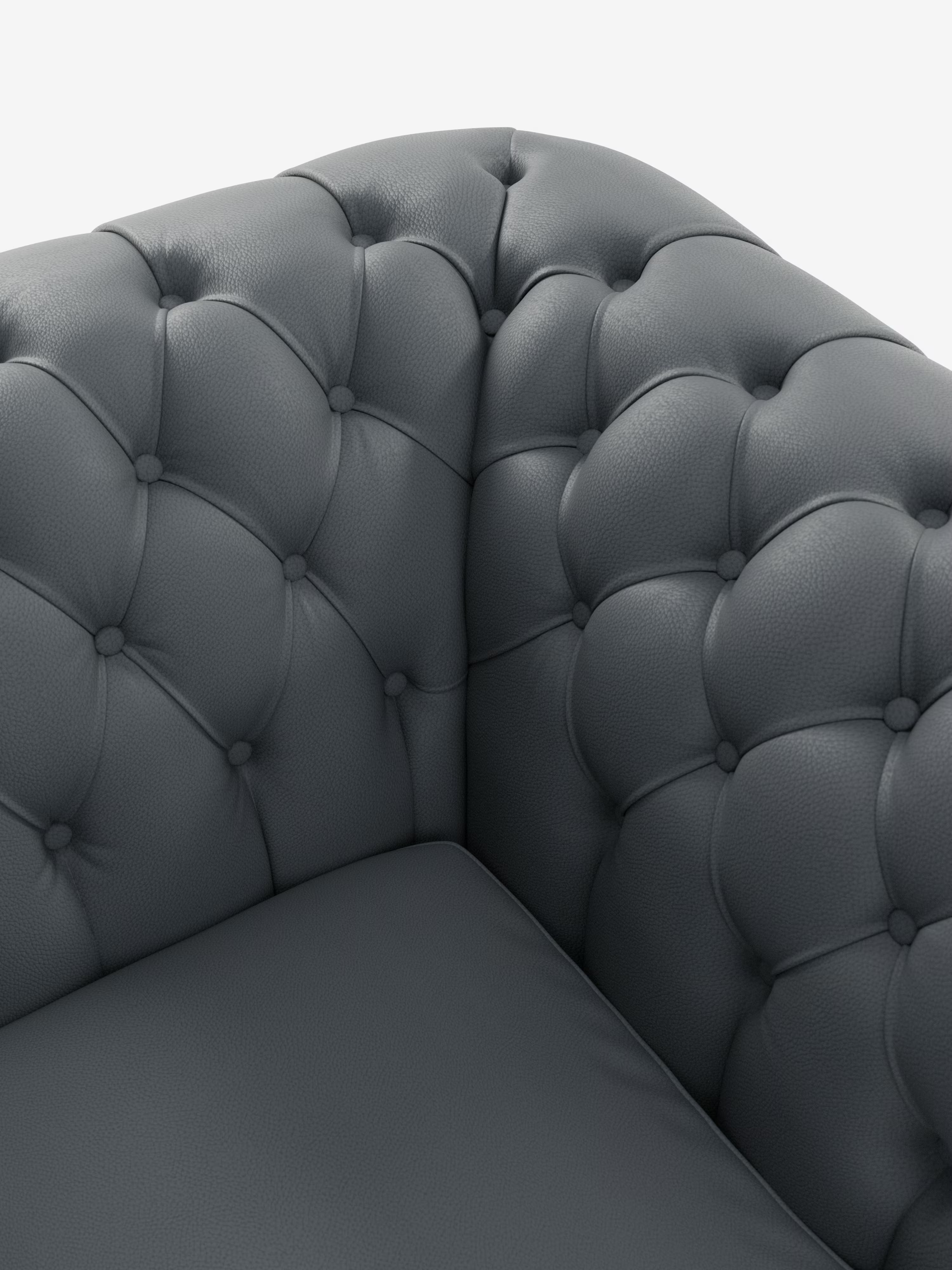 Primo piano della poltrona Chester in vera pelle spessorata con capitonné artigianale di Divani.Store, realizzata in pelle grigio scuro con rivestimento trapuntato a bottoni sullo schienale curvo e sui braccioli, e seduta liscia e imbottita. Lo sfondo è bianco a tinta unita.
