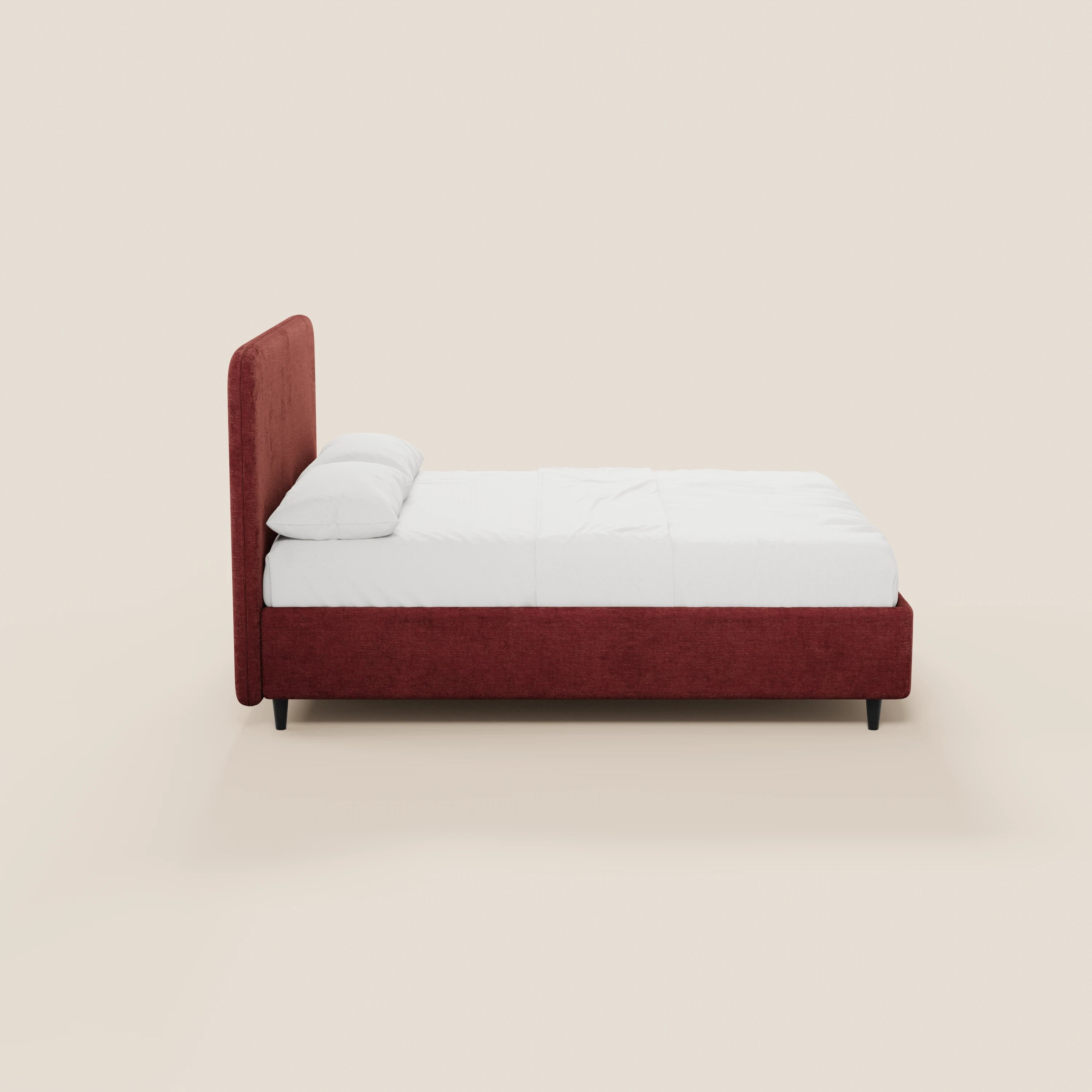 Una vista laterale del letto imbottito minimal KAELOS di Letti.store, caratterizzato da un'alta testiera arrotondata in ciniglia rossa e da una struttura coordinata con gambe alte nere e vano contenitore. Il letto è rifinito con biancheria da letto bianca e due cuscini, su uno sfondo beige chiaro.