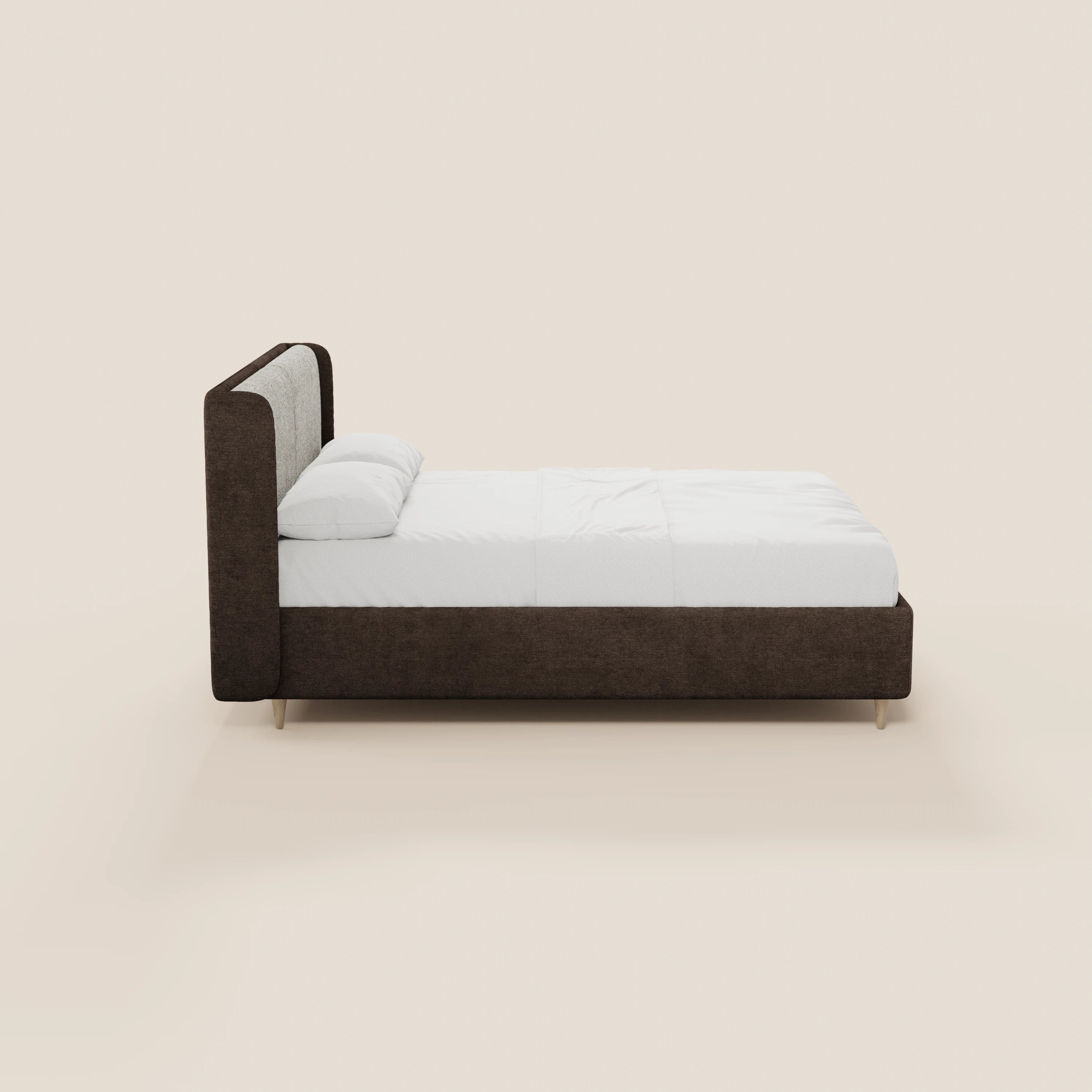 Vista laterale del letto imbottito bicolore VALKIRIA di Letti.store, caratterizzato da una struttura rivestita in marrone scuro con testiera ricurva, biancheria da letto e cuscini bianchi e gambe corte e leggere. Immagine scattata su sfondo beige: elegante design italiano.