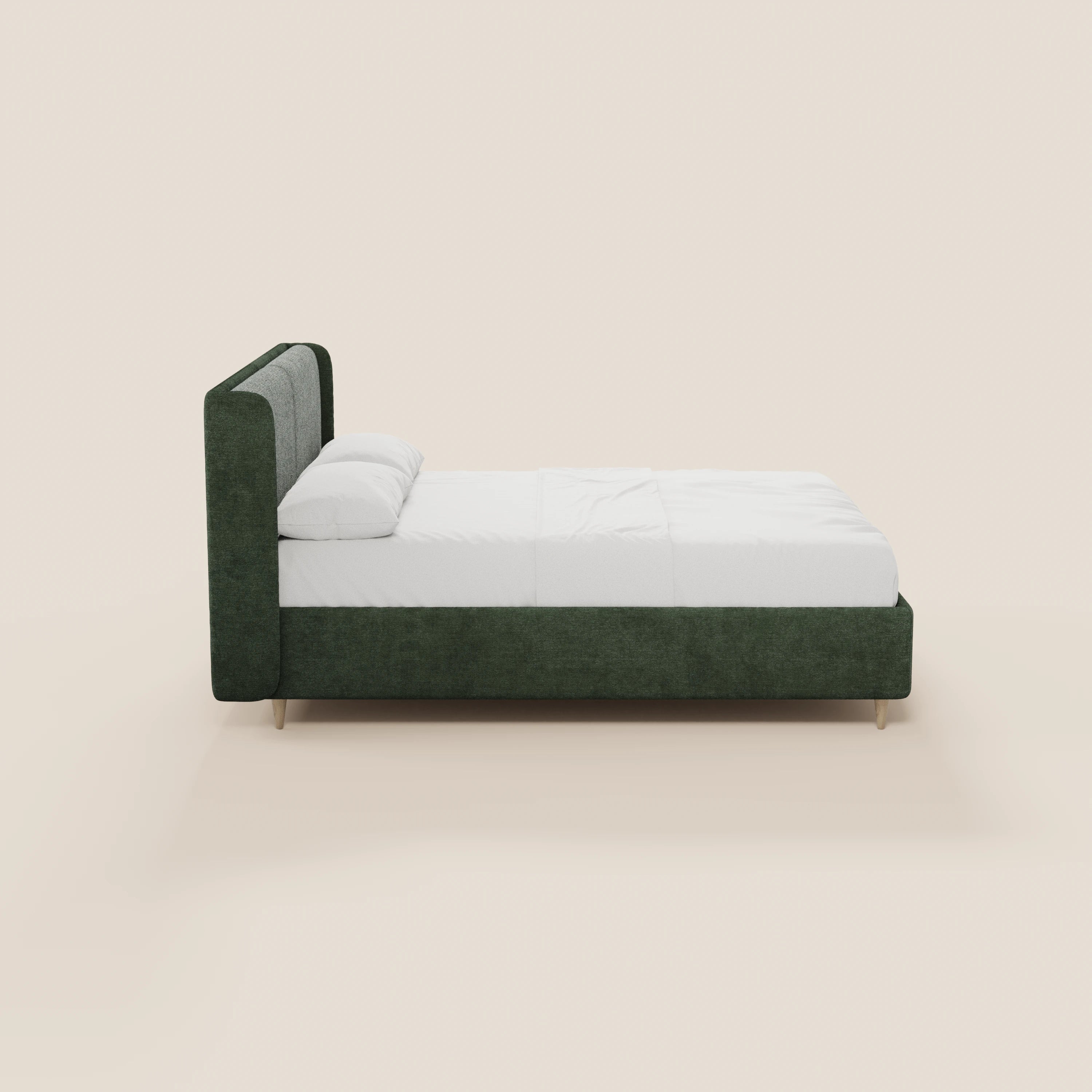 Una vista laterale del letto imbottito bicolore VALKIRIA di Letti.store, con struttura rivestita di verde, testiera ricurva e cuscini dello schienale, biancheria da letto bianca, due cuscini e gambe corte in legno chiaro, su uno sfondo beige chiaro a tinta unita.