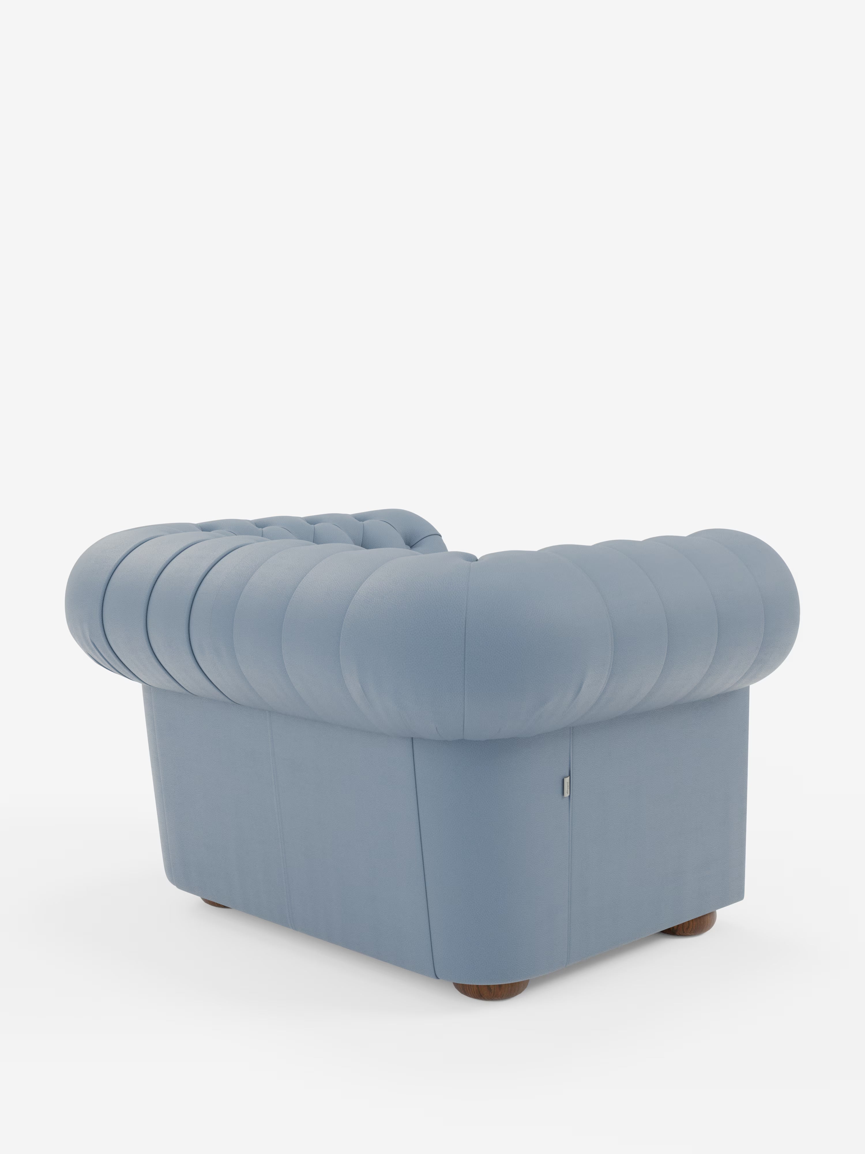 Ecco una versione rielaborata della frase utilizzando i dati del tuo prodotto: Una vista posteriore della poltrona Chester in vera pelle spessorata con capitonné artigianale di Divani.Store, caratterizzata da un morbido rivestimento azzurro con capitonné artigianale e da uno schienale arrotondato che ricorda una nuvola. Ispirata al classico design Chesterfield, questa poltrona poggia su gambe corte in legno ed è esposta su uno sfondo bianco a tinta unita.