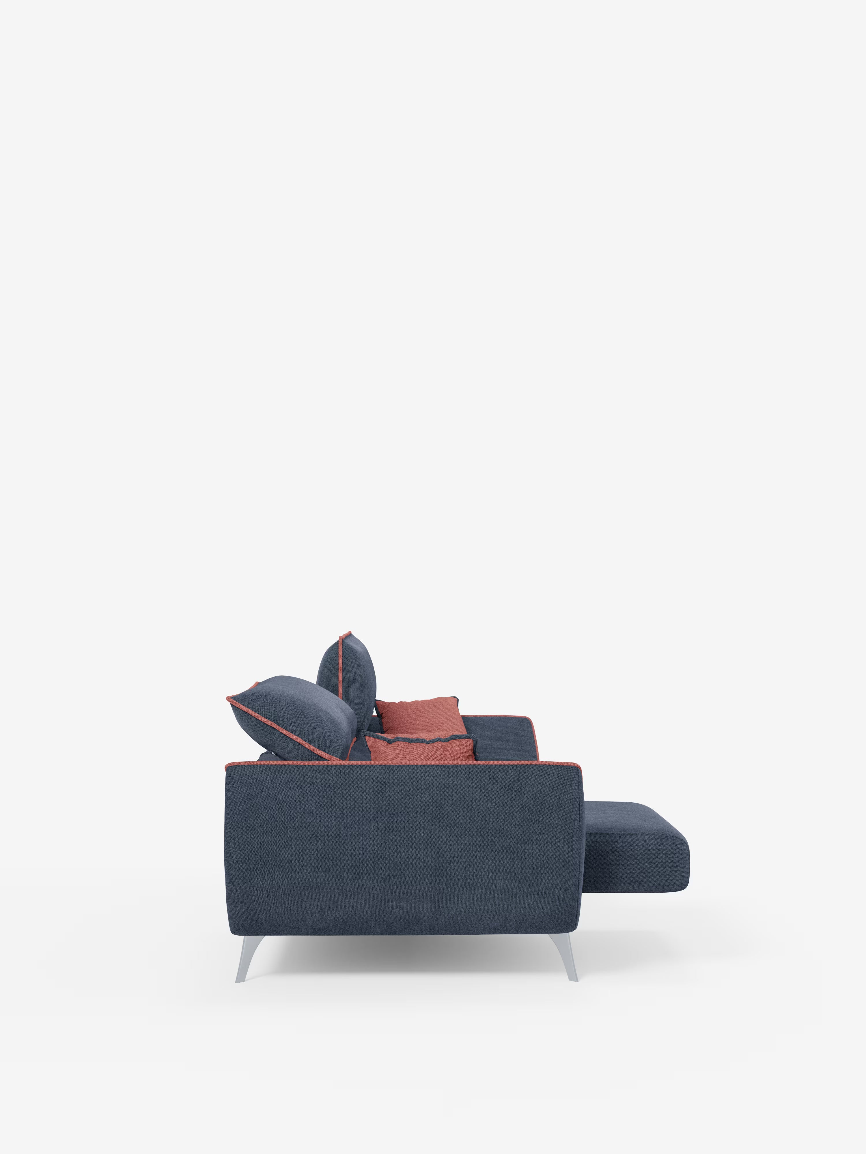 Il divano contemporaneo Michelangelo a 2 e 3 posti di Divani.Store, presentato in una versione bicolore con tessuto T23 blu scuro smacchiabile e rifiniture e cuscini rossi a contrasto, viene mostrato di profilo. Questo divano moderno presenta eleganti gambe angolari in metallo e una chaise longue estesa sulla destra, su uno sfondo bianco a tinta unita, e coniuga stile e comfort grazie alle sue spaziose sedute allungabili e ai poggiatesta reclinabili regolabili.
