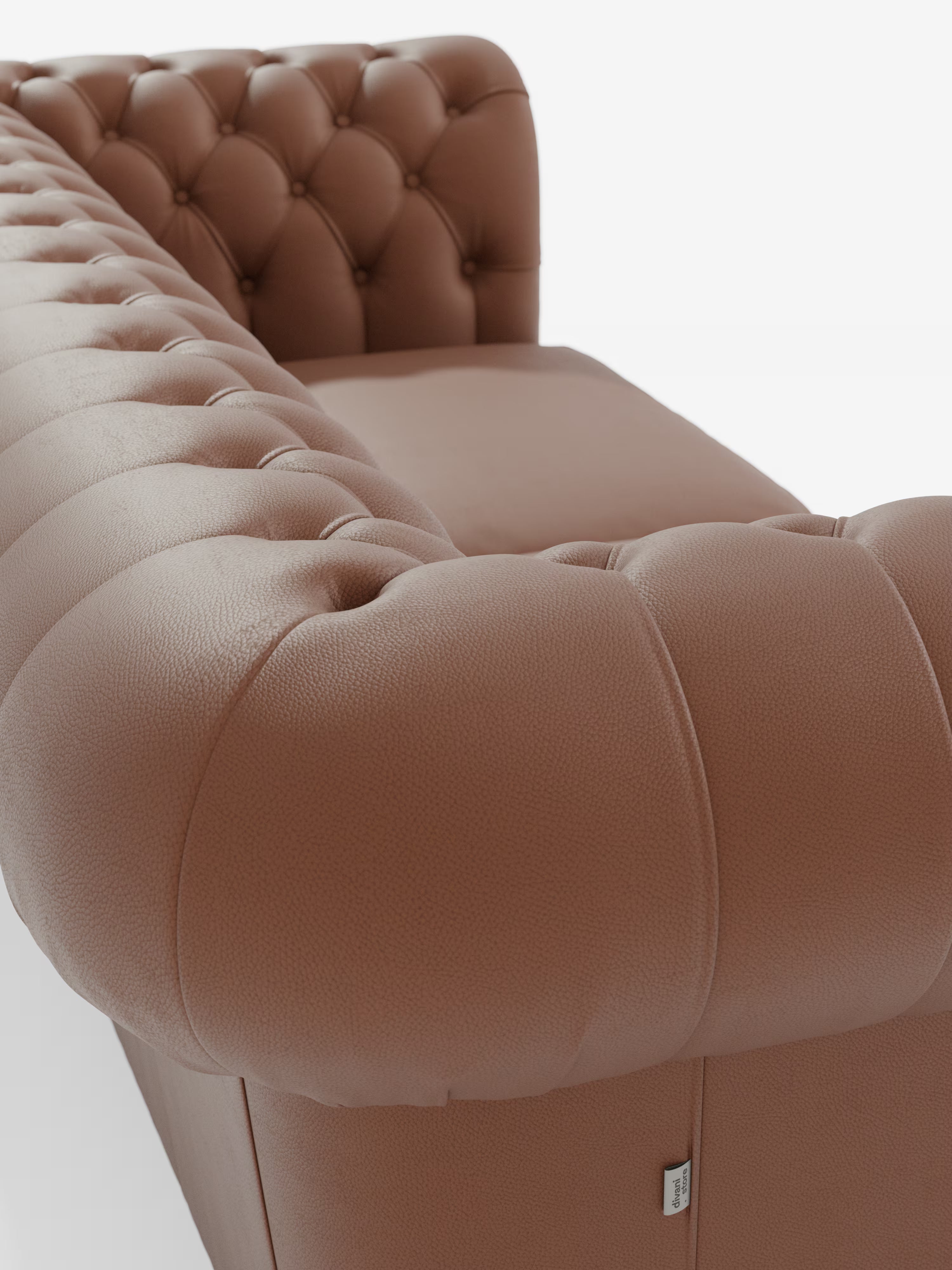 Primo piano del “Chester – Divano Chesterfield in vera pelle spessorata a 2 e 3 posti” di Divani.Store, caratterizzato dal rivestimento in pelle marrone con schienale trapuntato e braccioli impreziositi da bottoni decorativi. Realizzato in vera pelle spessorata, la trama è chiaramente visibile nella foto scattata dall’alto e da dietro il bracciolo. Lo sfondo bianco e minimalista esalta l’eleganza artigianale di questo raffinato divano artigianale Made in Italy.