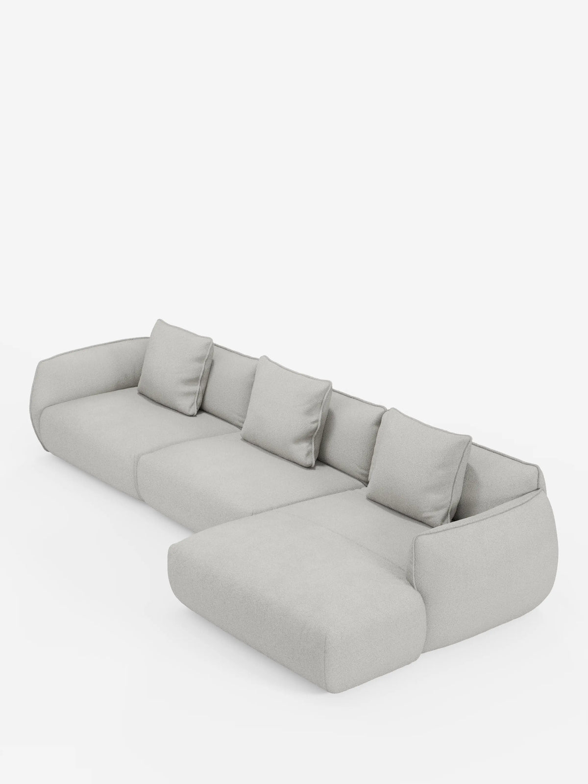 Il divano angolare con penisola componibile Nimbus in morbido tessuto effetto cotone smacchiabile T33 di Divani.Store è un divano componibile moderno, di colore grigio chiaro, con la chaise longue posizionata sul lato destro. Questo divano moderno è dotato di quattro cuscini dello schienale coordinati e braccioli arrotondati, tutti rivestiti in un tessuto morbido, soffice e antimacchia effetto cotone. Il divano è presentato su uno sfondo bianco a tinta unita.
