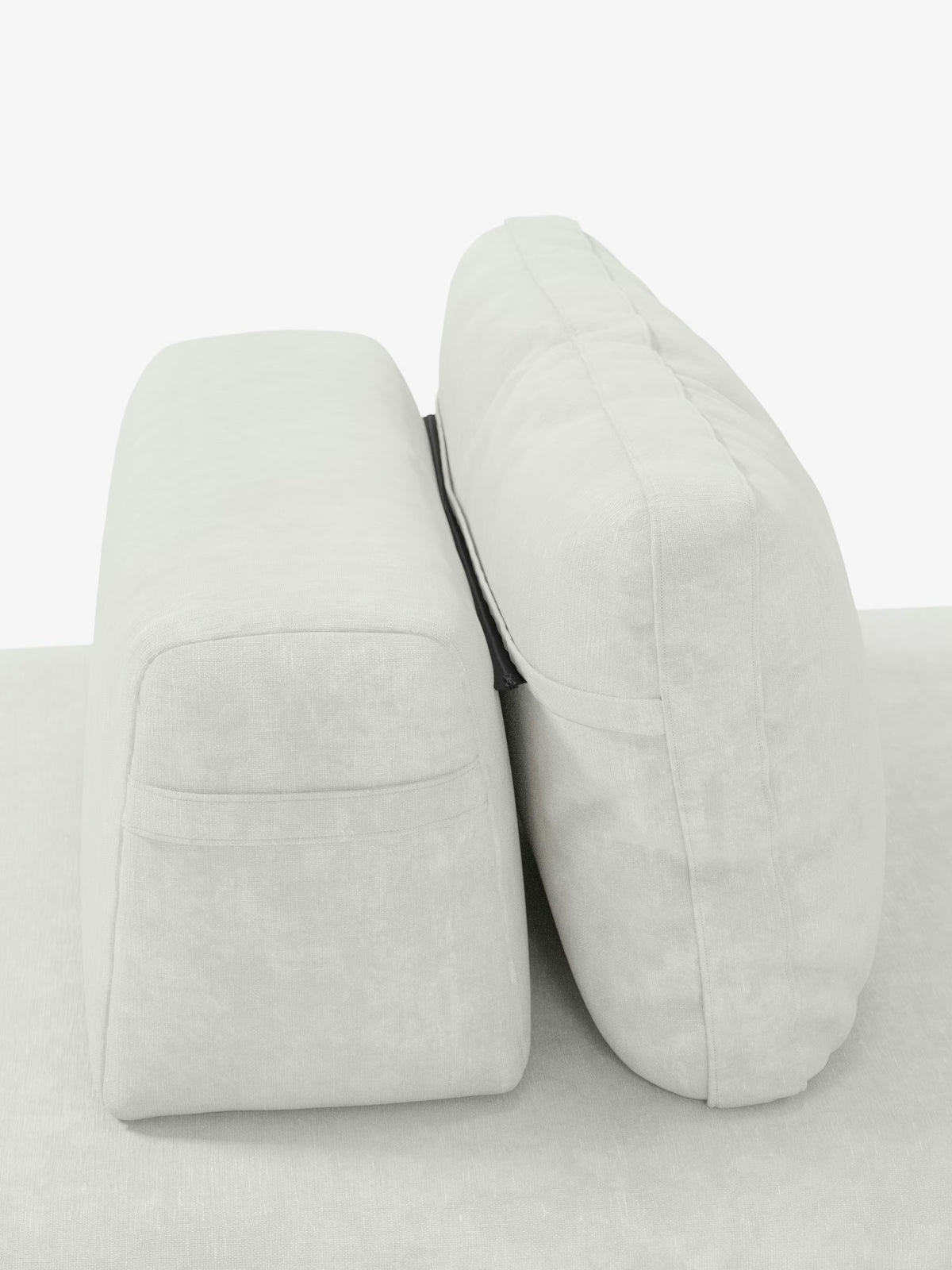 Due cuscini di seduta rettangolari di colore grigio chiaro sono disposti uno accanto all’altro sulla base del divano letto matrimoniale Rift a 2 e 3 posti con schienali mobili di Divani.Store. Una sottile linea nera li divide verticalmente, richiamando l’estetica elegante e moderna del divano. Il cuscino di sinistra appare più squadrato, mentre quello di destra è più alto e arrotondato. Lo sfondo è bianco.