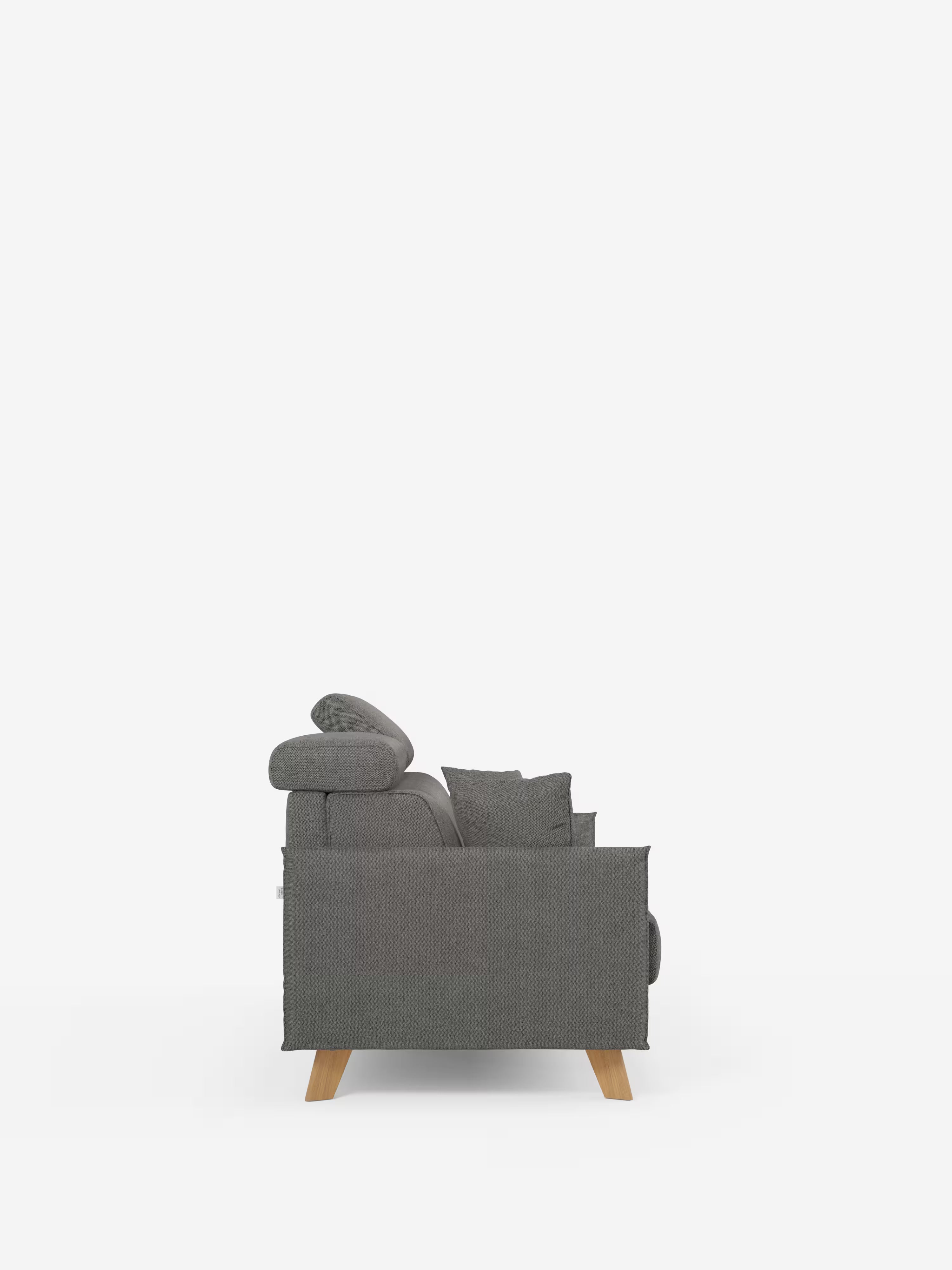 Vista laterale del divano letto matrimoniale Sole di Divani.Store, caratterizzato da un moderno rivestimento in tessuto T23 grigio antimacchia e da un design compatto e minimalista. Il divano presenta uno schienale basso con poggiatesta regolabili, cuscino coordinato, braccioli imbottiti e gambe in legno chiaro. Su uno sfondo bianco a tinta unita, questo divano con rivestimento sfoderabile al 100% coniuga lo stile contemporaneo con la praticità.