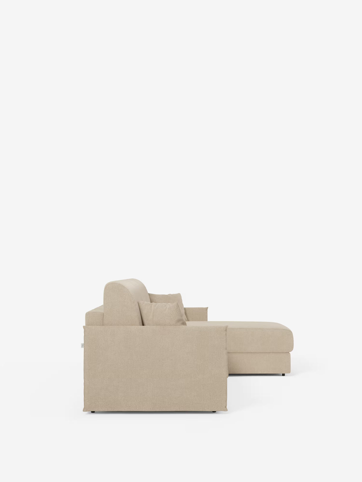 Vista laterale del divano letto angolare con penisola contenitore Evans di Divani.Store, un moderno divano componibile beige con chaise longue rivolta a destra. Questo modello compatto, rivestito in tessuto smacchiabile T23, presenta linee pulite, uno schienale basso, braccioli squadrati ed è dotato di due cuscini coordinati. Lo sfondo è bianco a tinta unita.