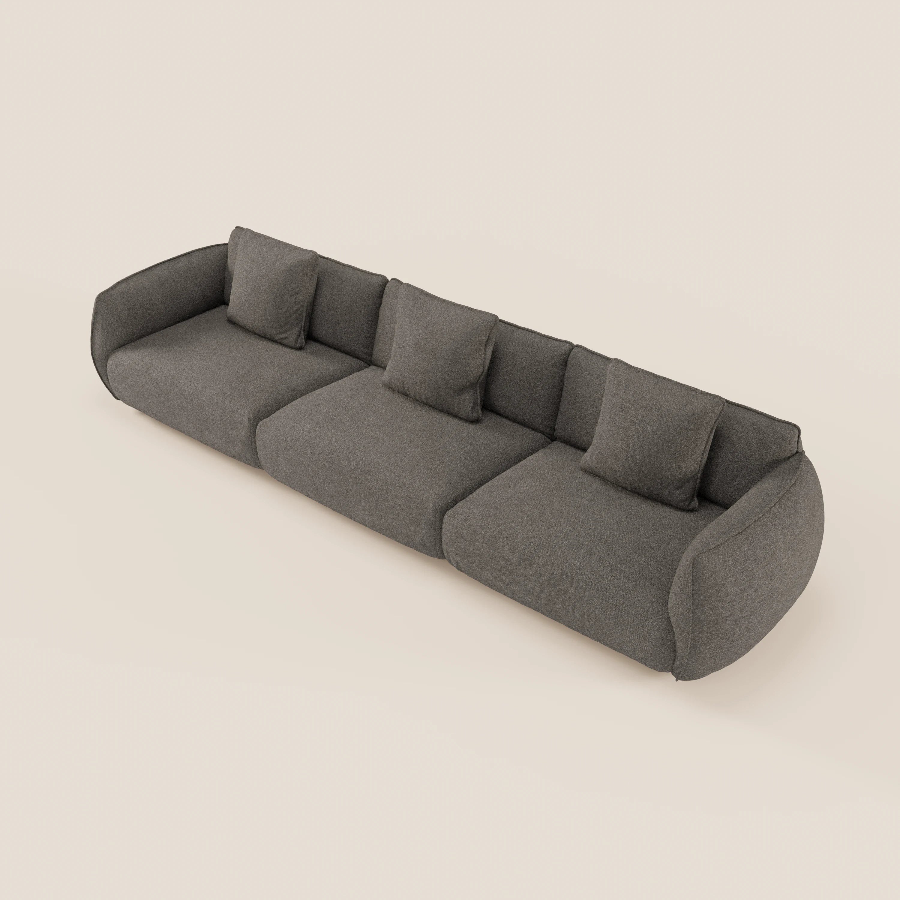 Vista dall'alto del divano modulare a 3 posti Nimbus di Divani.Store, caratterizzato da braccioli arrotondati e quattro cuscini quadrati coordinati in grigio scuro, rivestiti in morbido tessuto antimacchia effetto cotone T33 su sfondo beige chiaro.