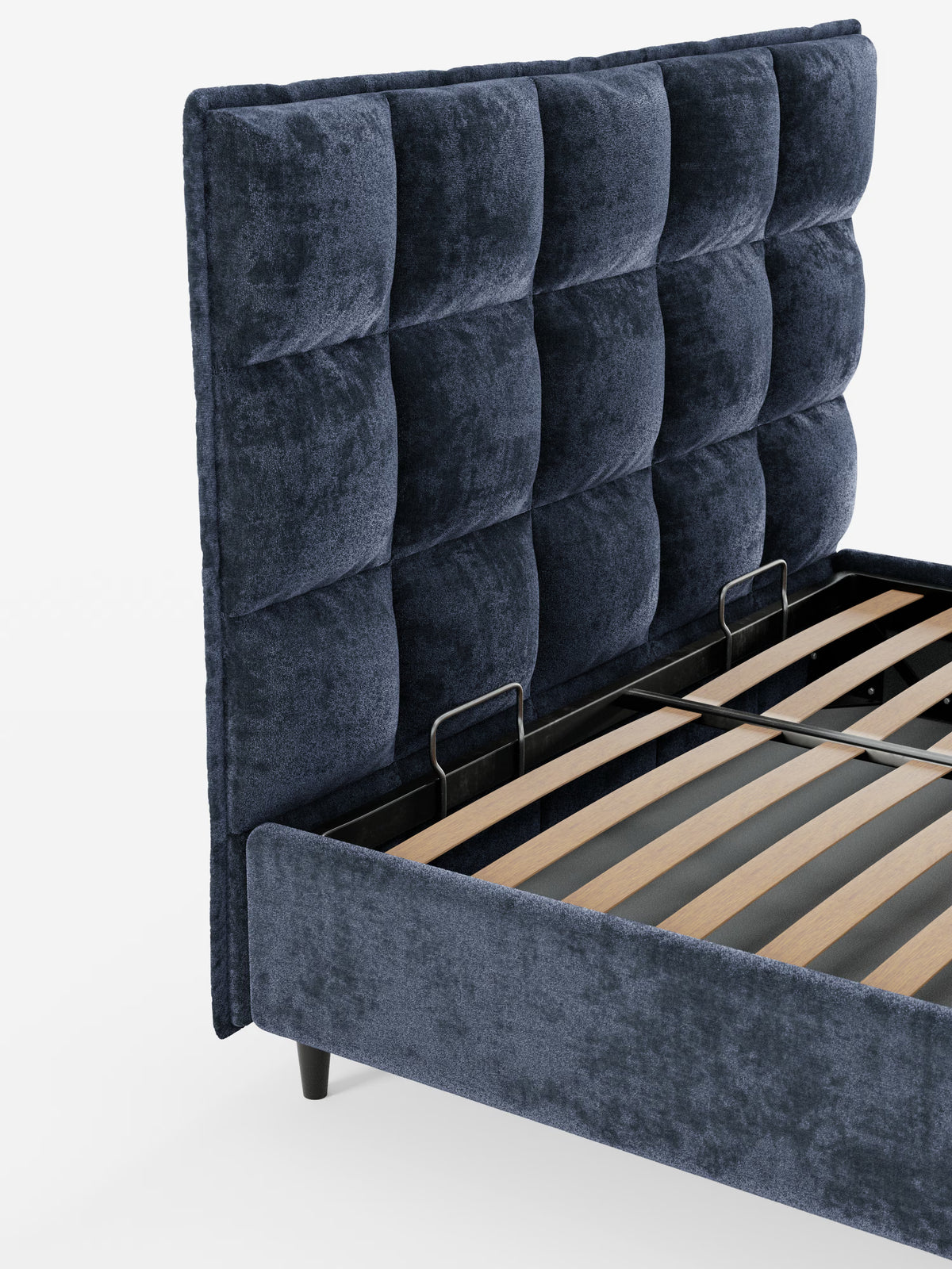 Un primo piano del letto imbottito con contenitore AURO di Letti.store, caratterizzato da un design moderno con una testiera alta e capitonné, rivestita in ciniglia blu navy certificata Oeko-Tex®. La struttura del letto è composta da robuste doghe in legno sostenute da travi metalliche a vista e poggia su corte gambe nere. In primo piano su uno sfondo bianco a tinta unita.