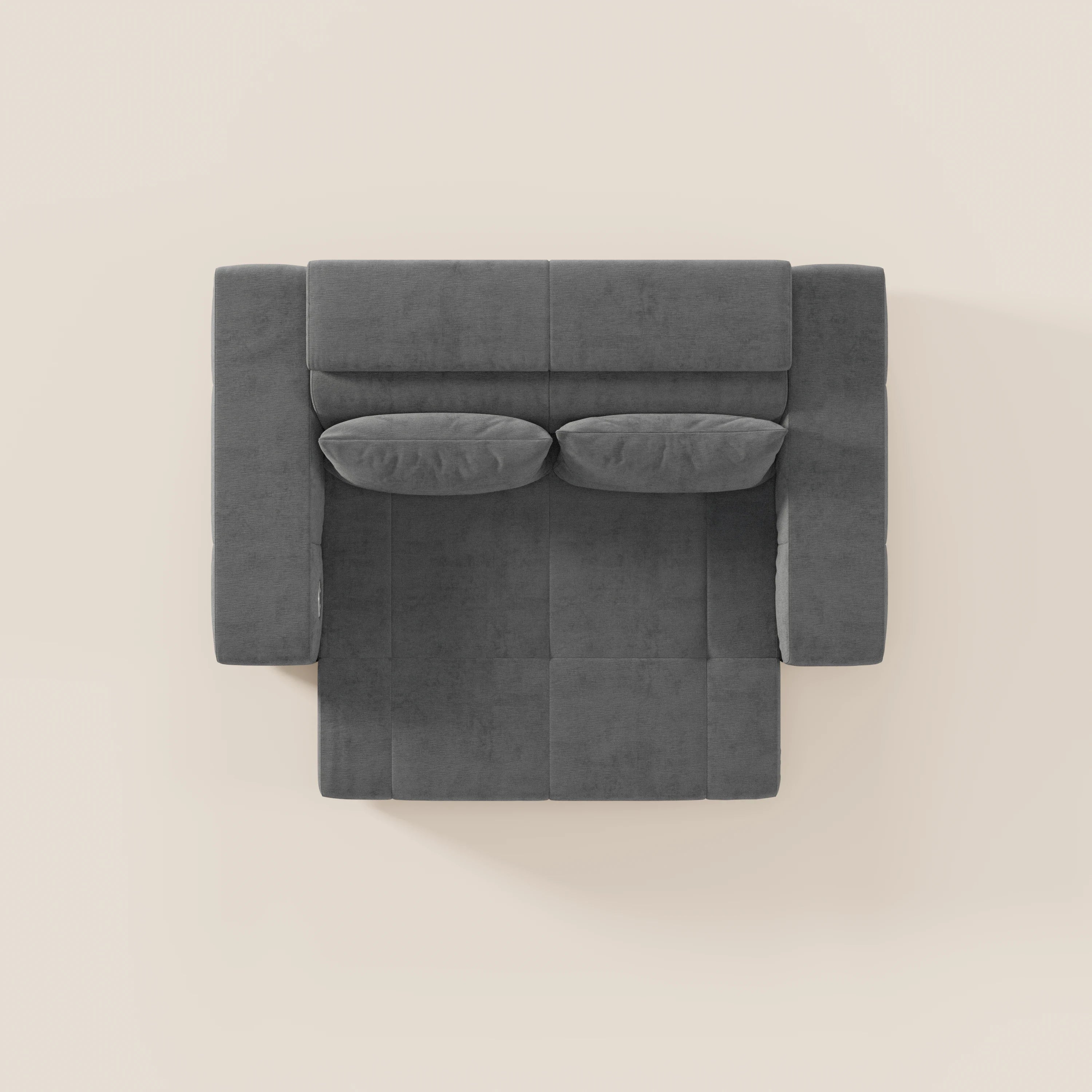 Vista dall'alto del Monarch Divano con Relax Elettrico di Divani.Store, di forma quadrata e di colore grigio scuro, con due cuscini rettangolari abbinati vicino allo schienale, su uno sfondo beige chiaro.