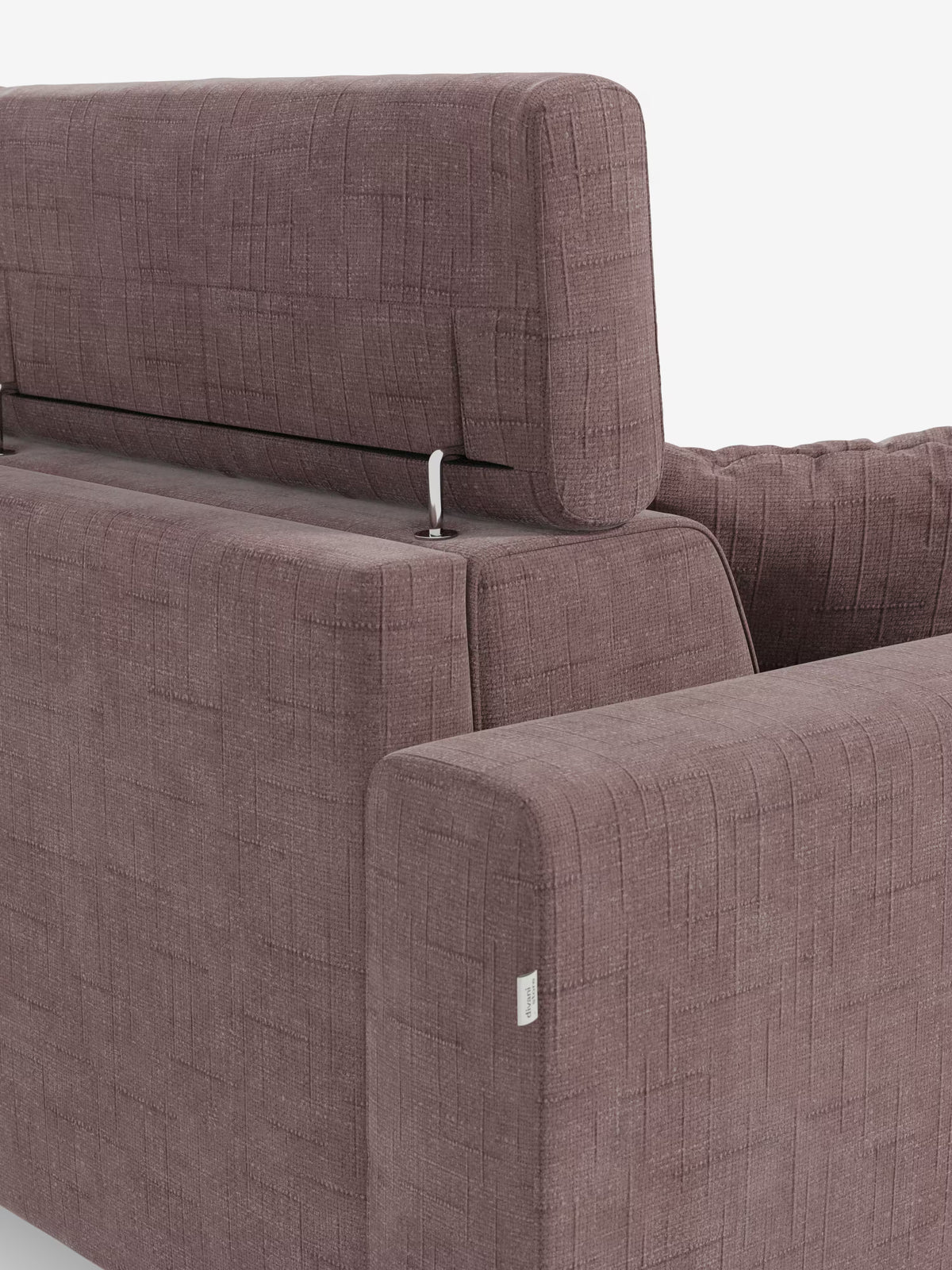 Un primo piano del divano letto angolare Pegaso con poggiatesta reclinabili e penisola contenitore in tessuto jacquard smacchiabile T22 di Divani.Store mette in risalto il suo moderno tessuto color malva con motivo geometrico, evidenziando i braccioli, lo schienale e un poggiatesta regolabile sostenuto da un'asta metallica a vista. La trama dettagliata e le cuciture sottolineano il design contemporaneo unito a un comfort pratico.