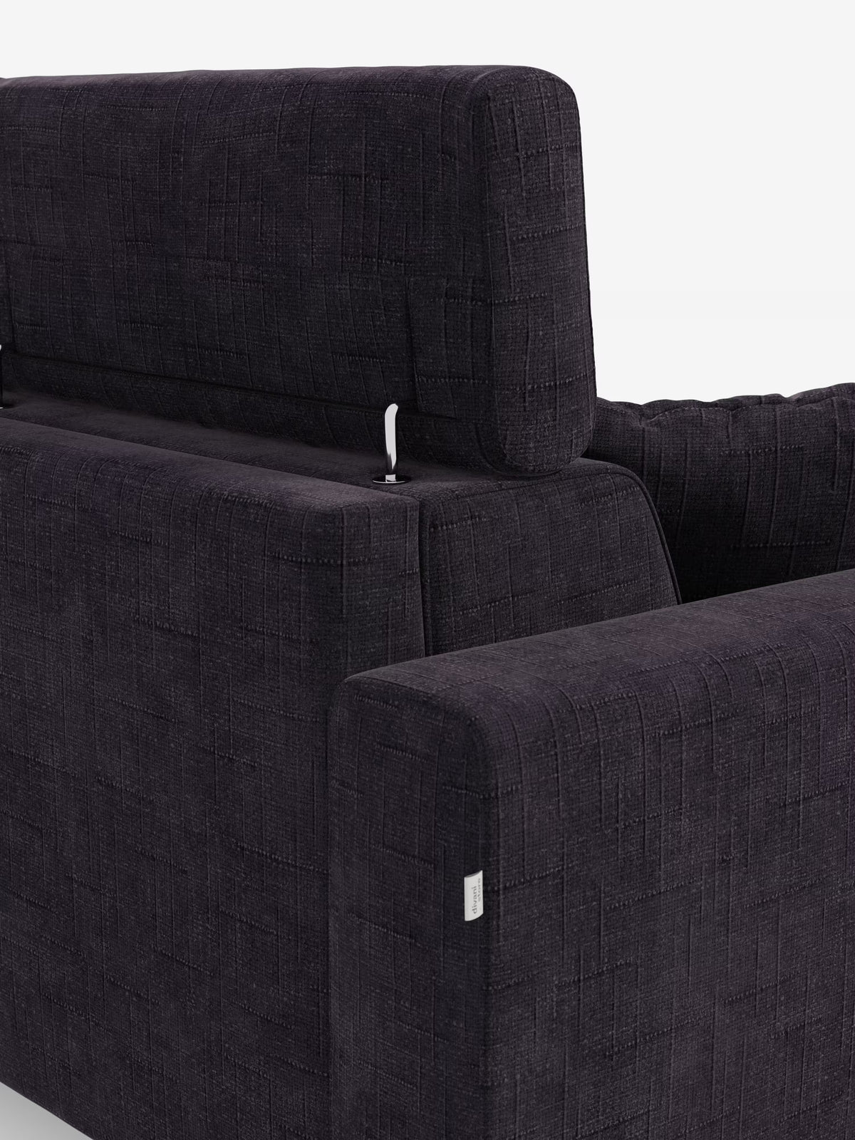 Primo piano del divano letto angolare Pegaso di Divani.Store, caratterizzato da elementi di design moderno quali lo schienale, i braccioli e le cuciture curate nei dettagli. Il divano è rivestito in tessuto jacquard T22 testurizzato e resistente alle macchie, con un motivo a griglia, e presenta un'etichetta in tessuto visibile sul lato. I poggiatesta reclinabili e la chaise longue con vano portaoggetti ne aumentano la funzionalità. Immagine su sfondo bianco.