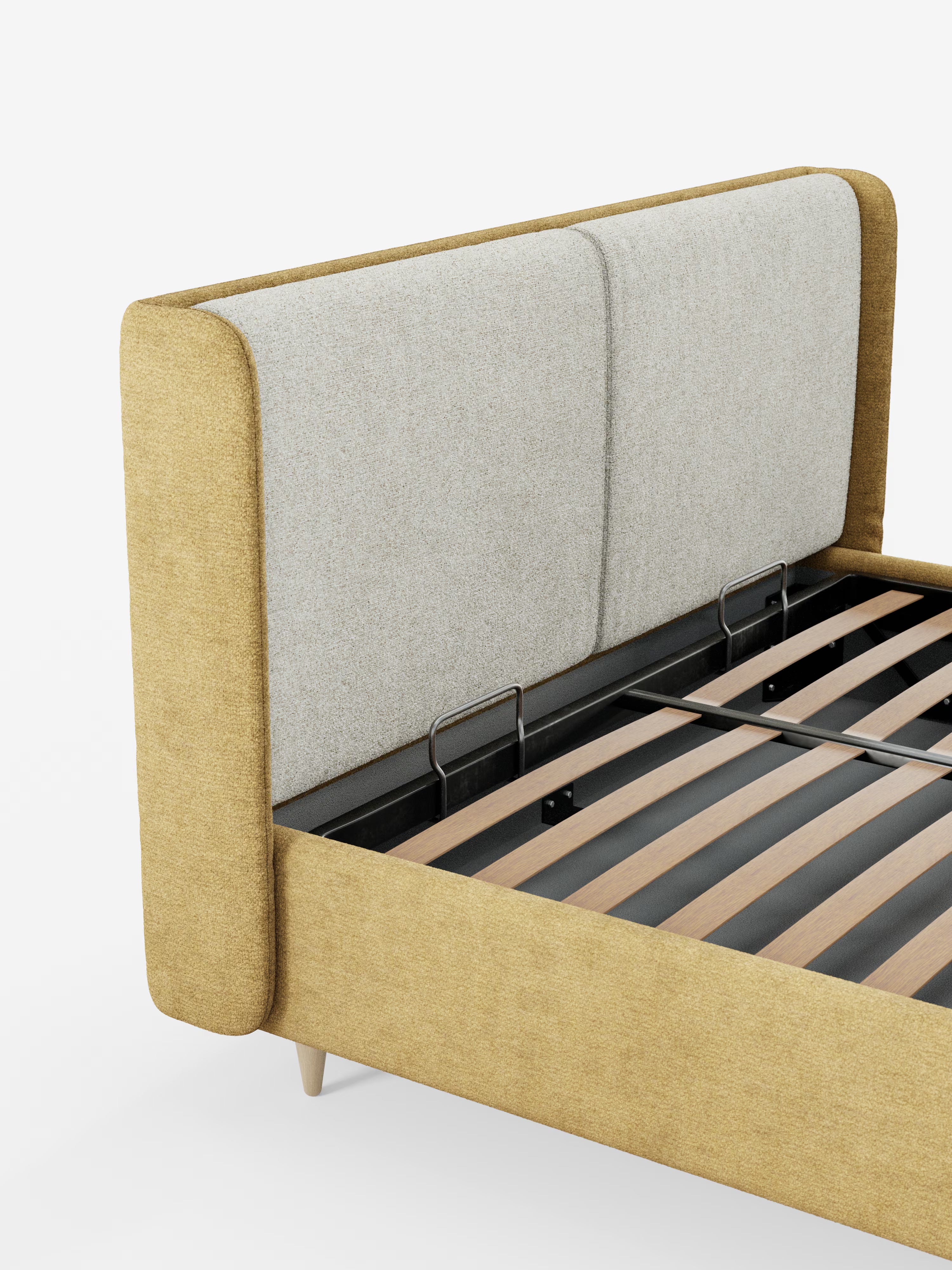Un letto imbottito contemporaneo VALKIRIA bicolore con contenitore di Letti.store, caratterizzato da un rivestimento giallo senape e da una testiera alta, curva, imbottita, di colore grigio chiaro, con cuscini dello schienale integrati. La struttura presenta doghe in legno a vista e supporti in metallo nero, completati da gambe affusolate in legno chiaro. Presentato su uno sfondo bianco a tinta unita.