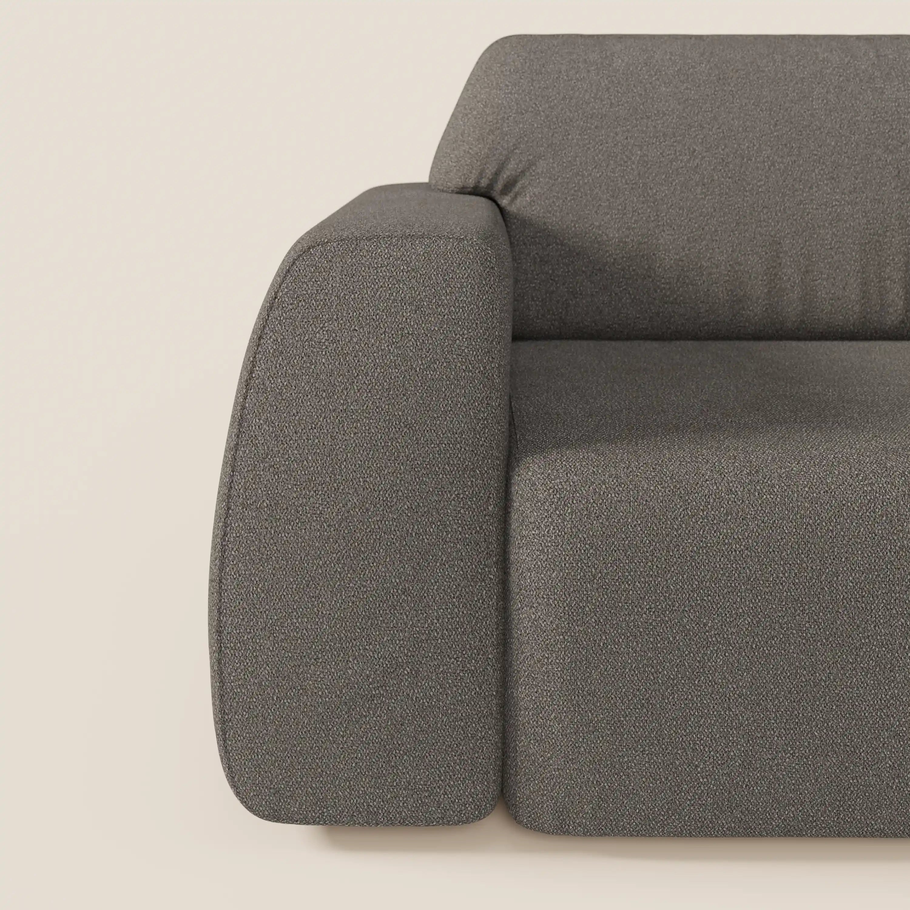 Primo piano del braccio sinistro e della seduta di Orbit divano con 3 sedute scorrevoli e allungabili in tessuto effetto cotone smacchiabile T33 di Divani.Store. L'ampio bracciolo arrotondato spicca su uno sfondo beige chiaro.